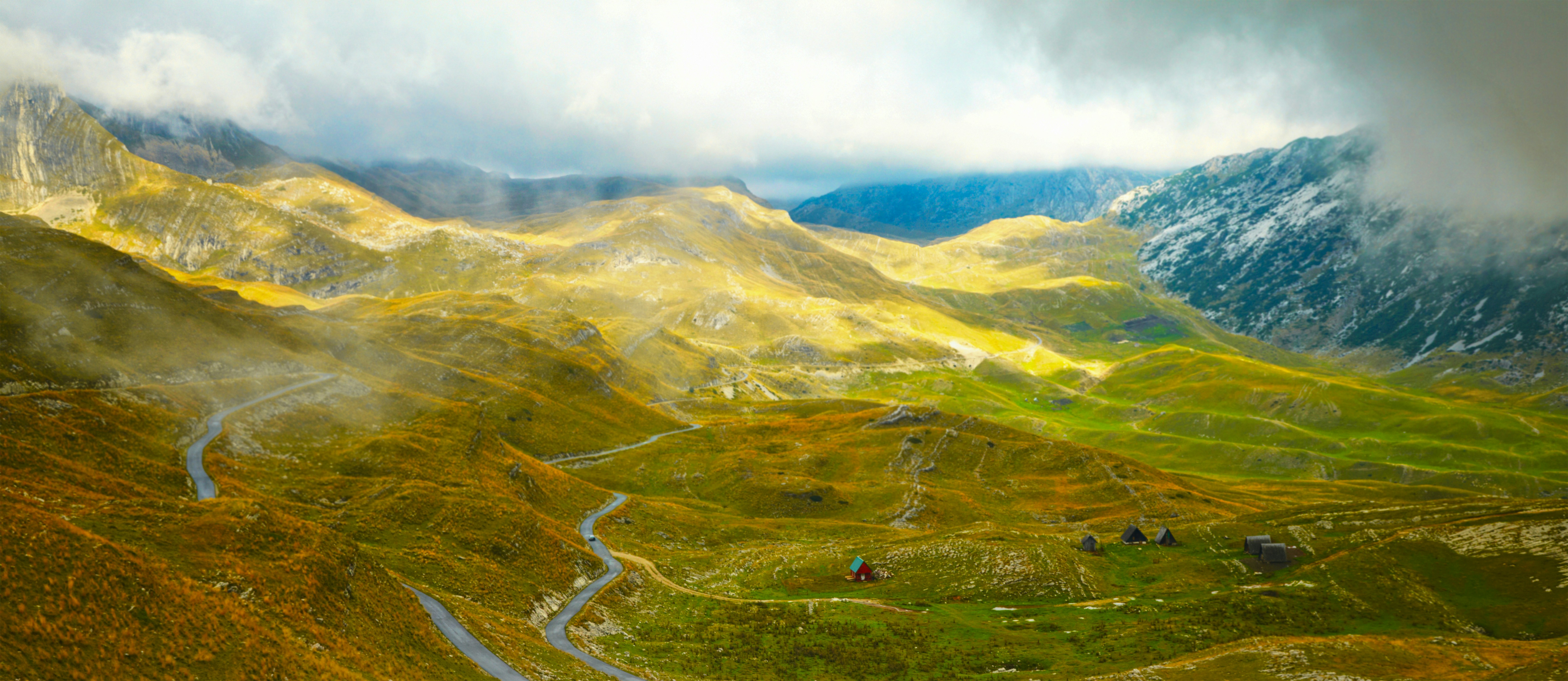 A painting of a mountain range with a river running through it