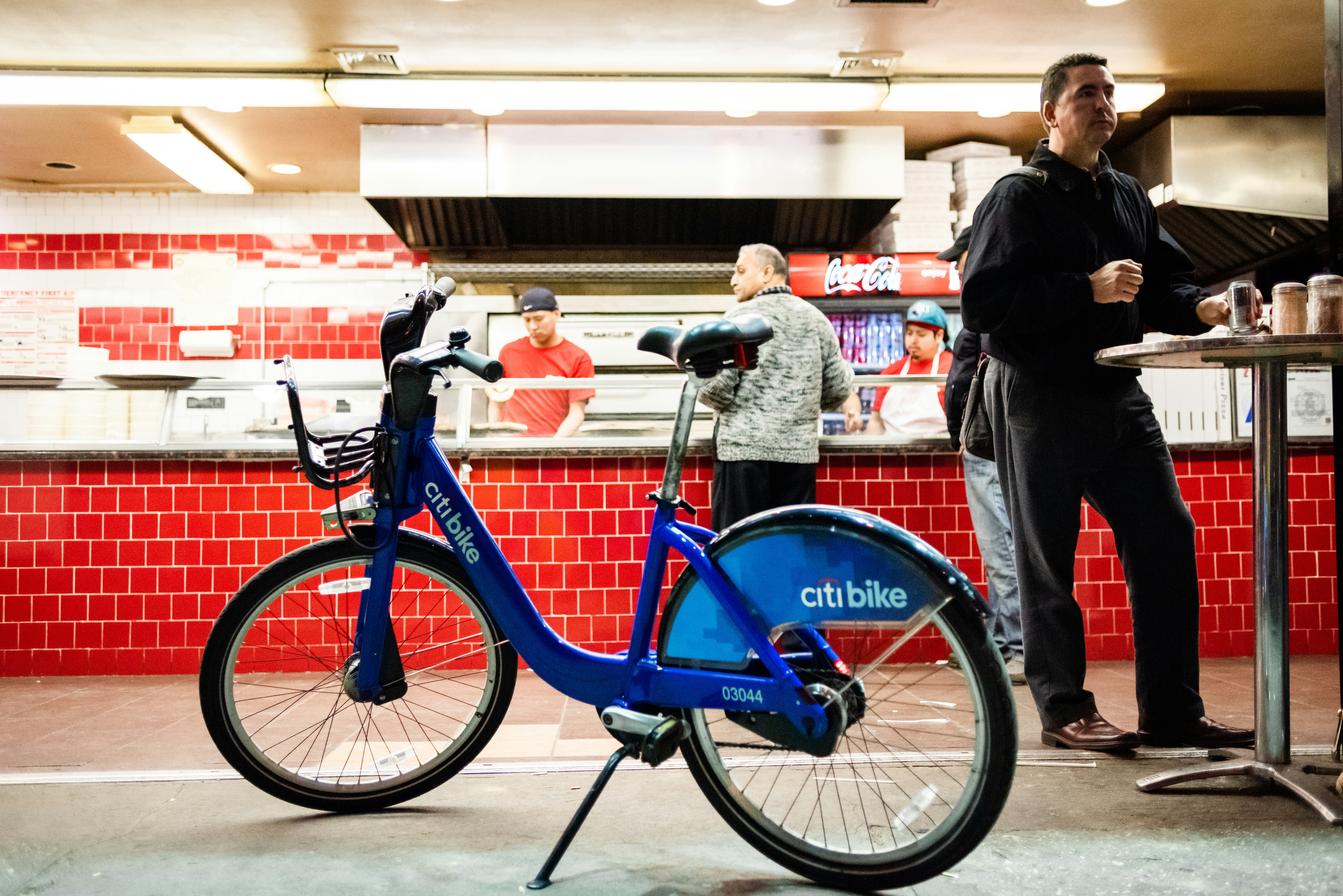 A man standing next to a blue bike
