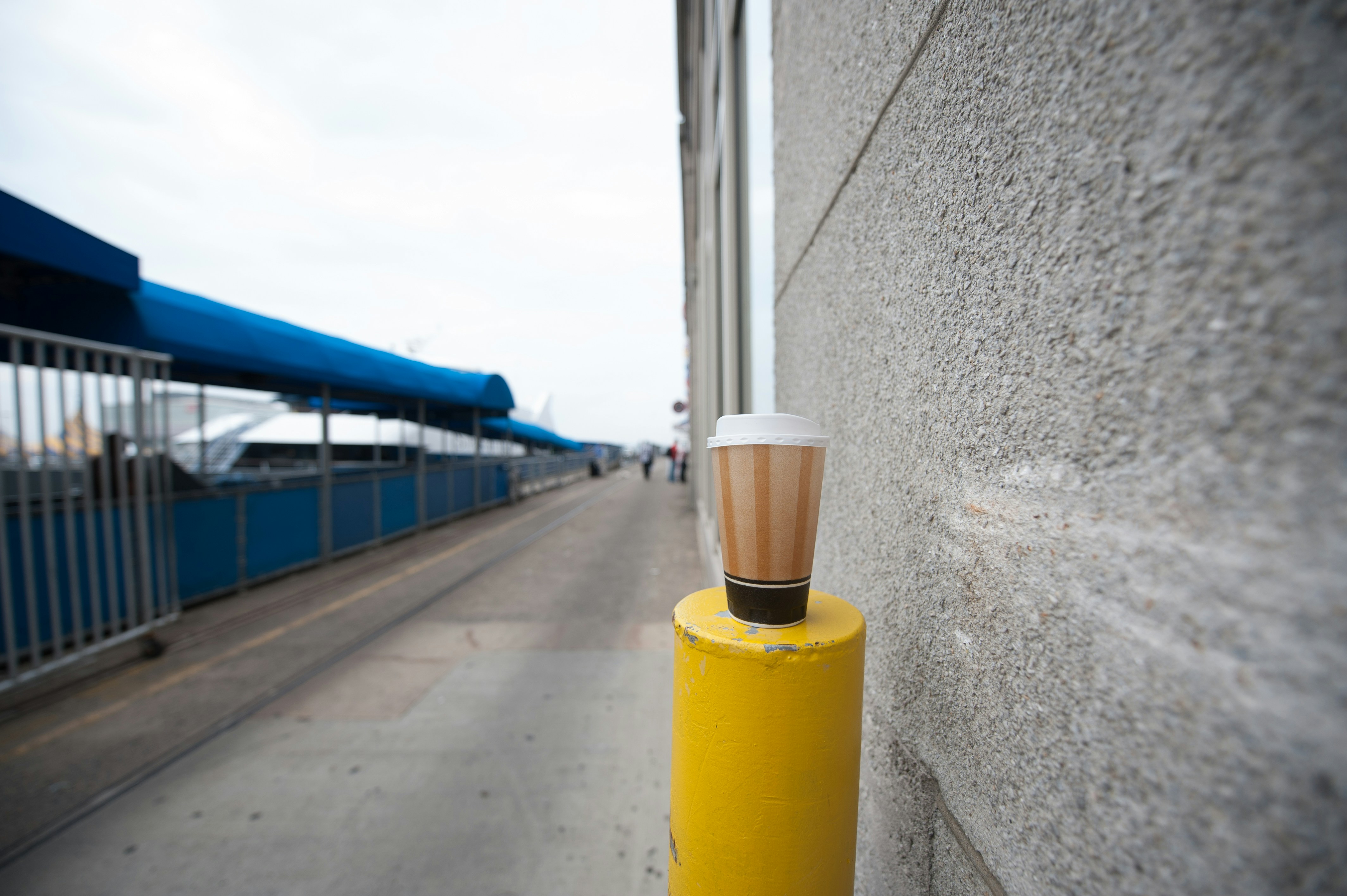 A cup of coffee sitting on top of a yellow pole