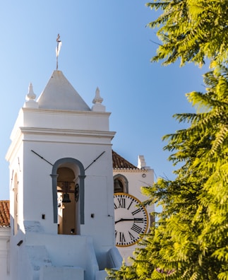 A white church with a clock on the front of it