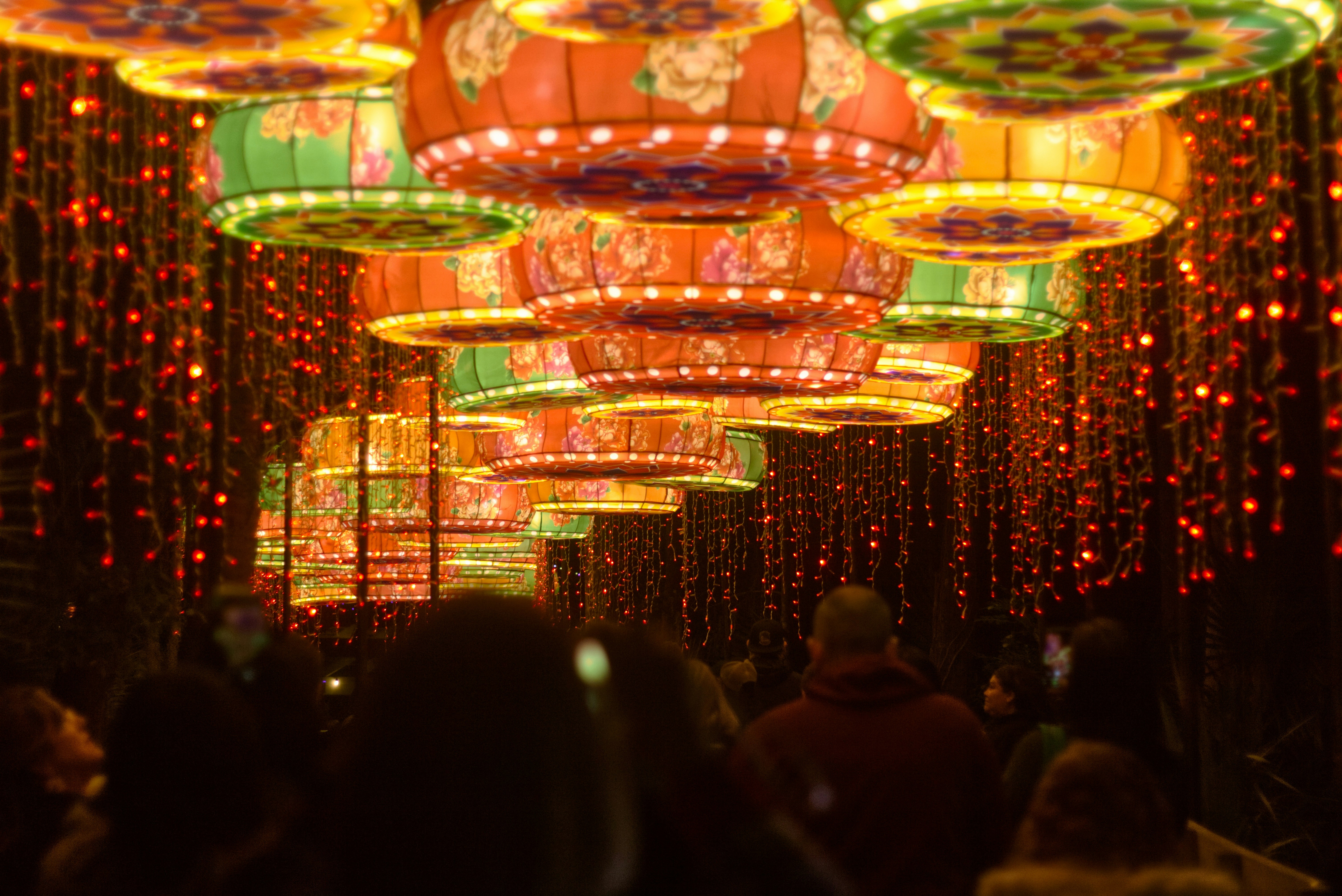 Un grupo de personas caminando por un túnel de luces