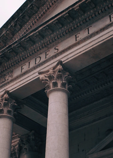 A tall building with columns and a clock on top of it