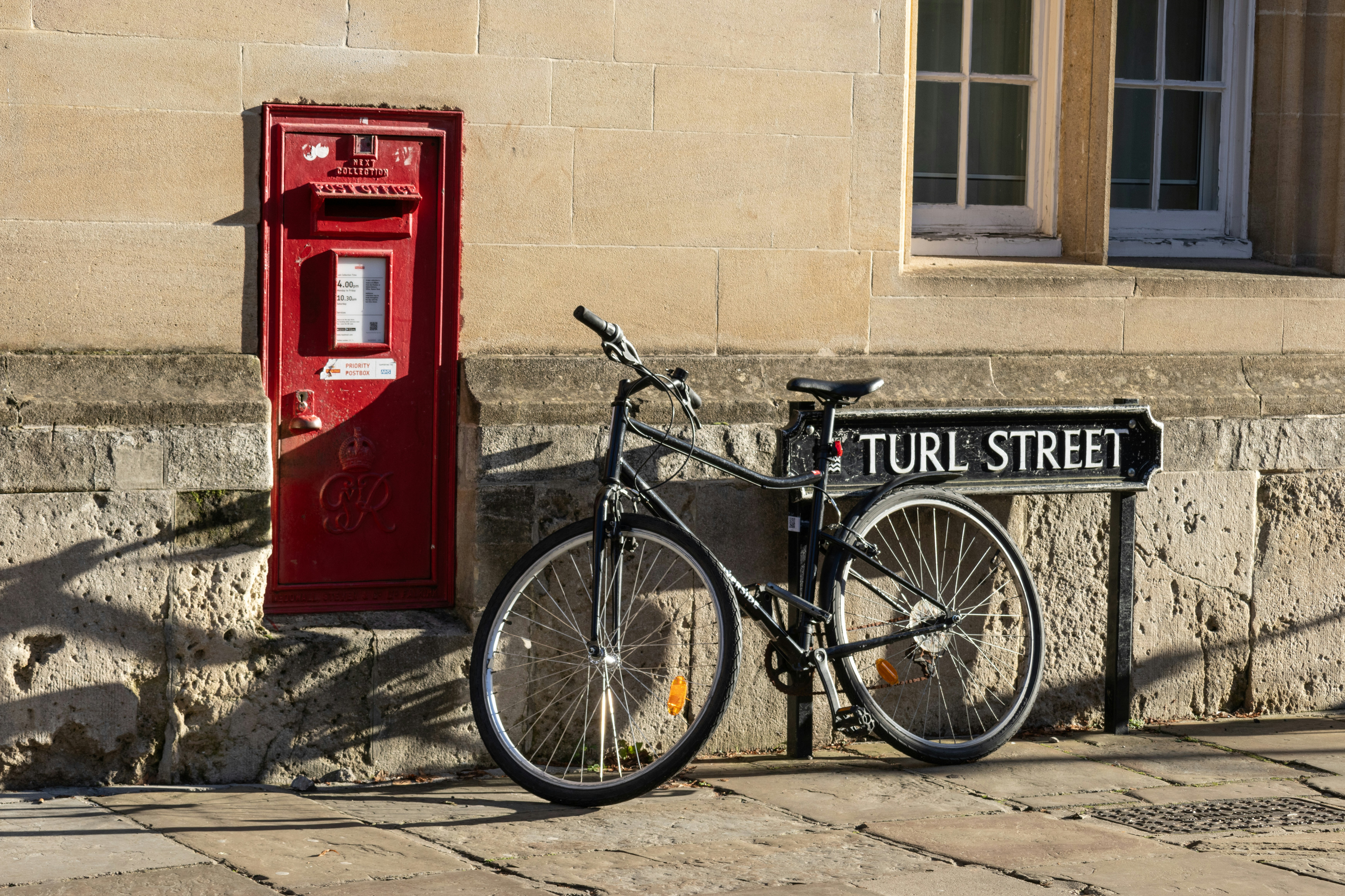Ein Fahrrad, das neben einem roten Briefkasten abgestellt ist