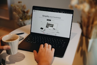 A person sitting at a table using a laptop computer