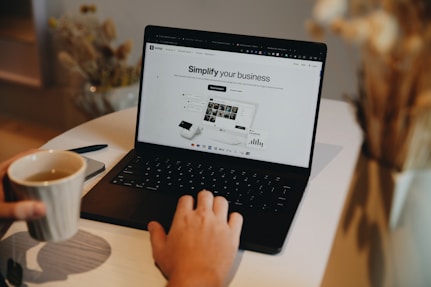 A person sitting at a table using a laptop computer