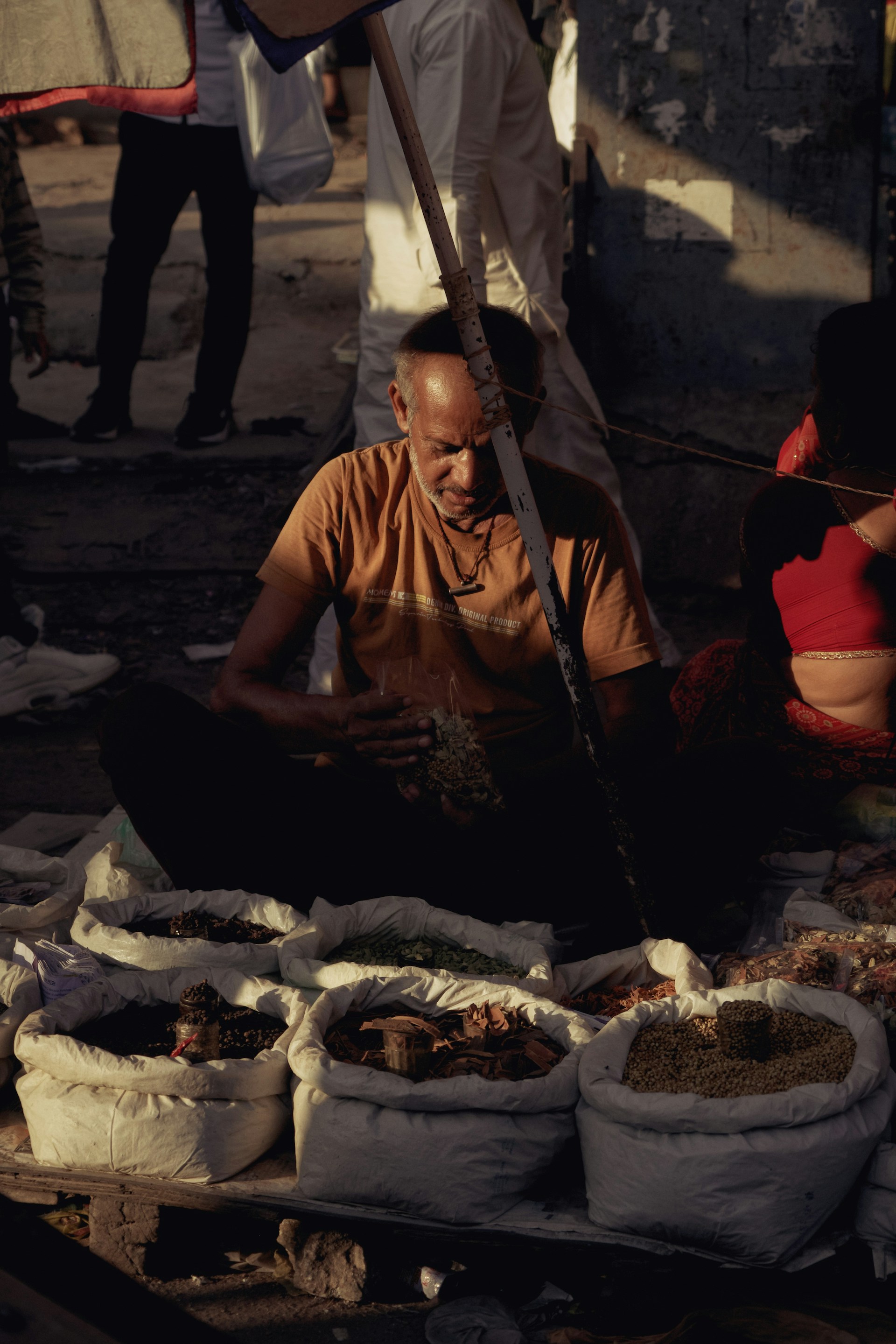 A man sitting on the ground in front of bags of food