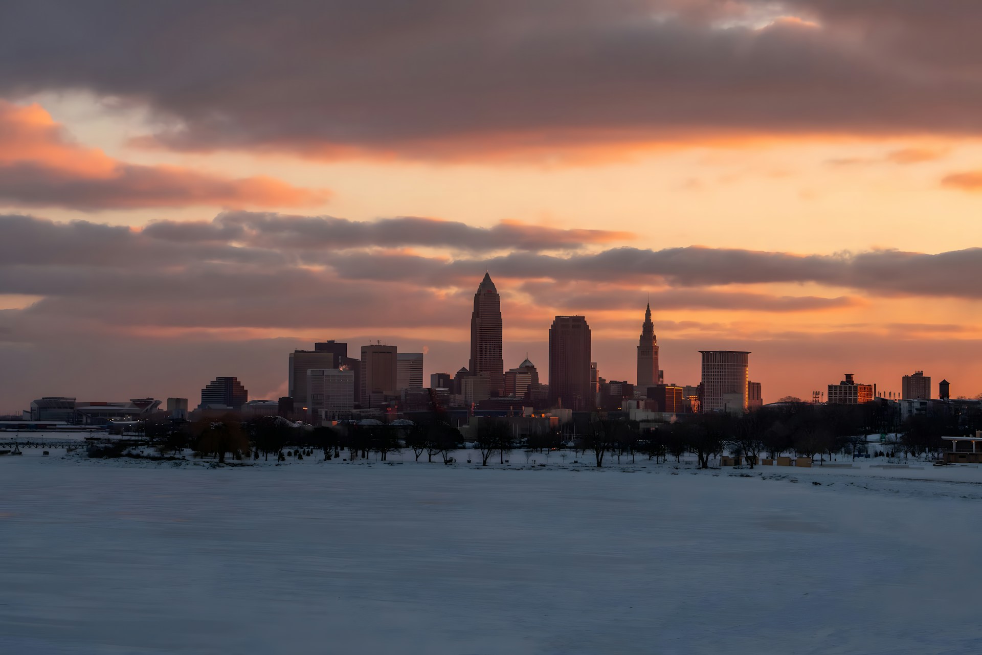 A view of a city in the distance with snow on the ground