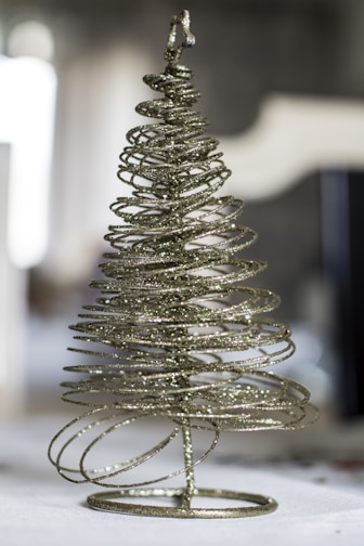 A wire christmas tree sitting on top of a table