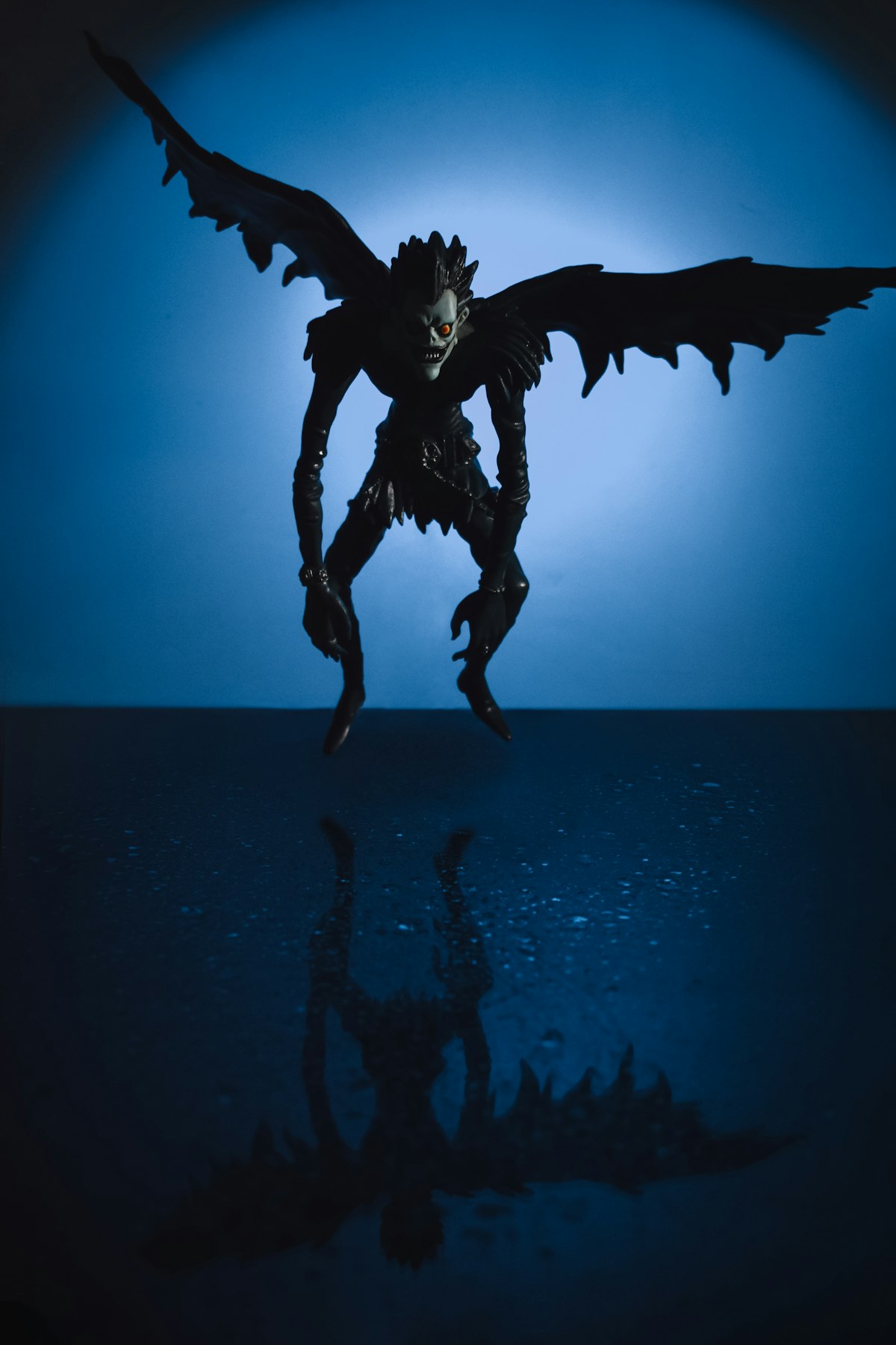 A demon silhouette in front of a dark blue background
