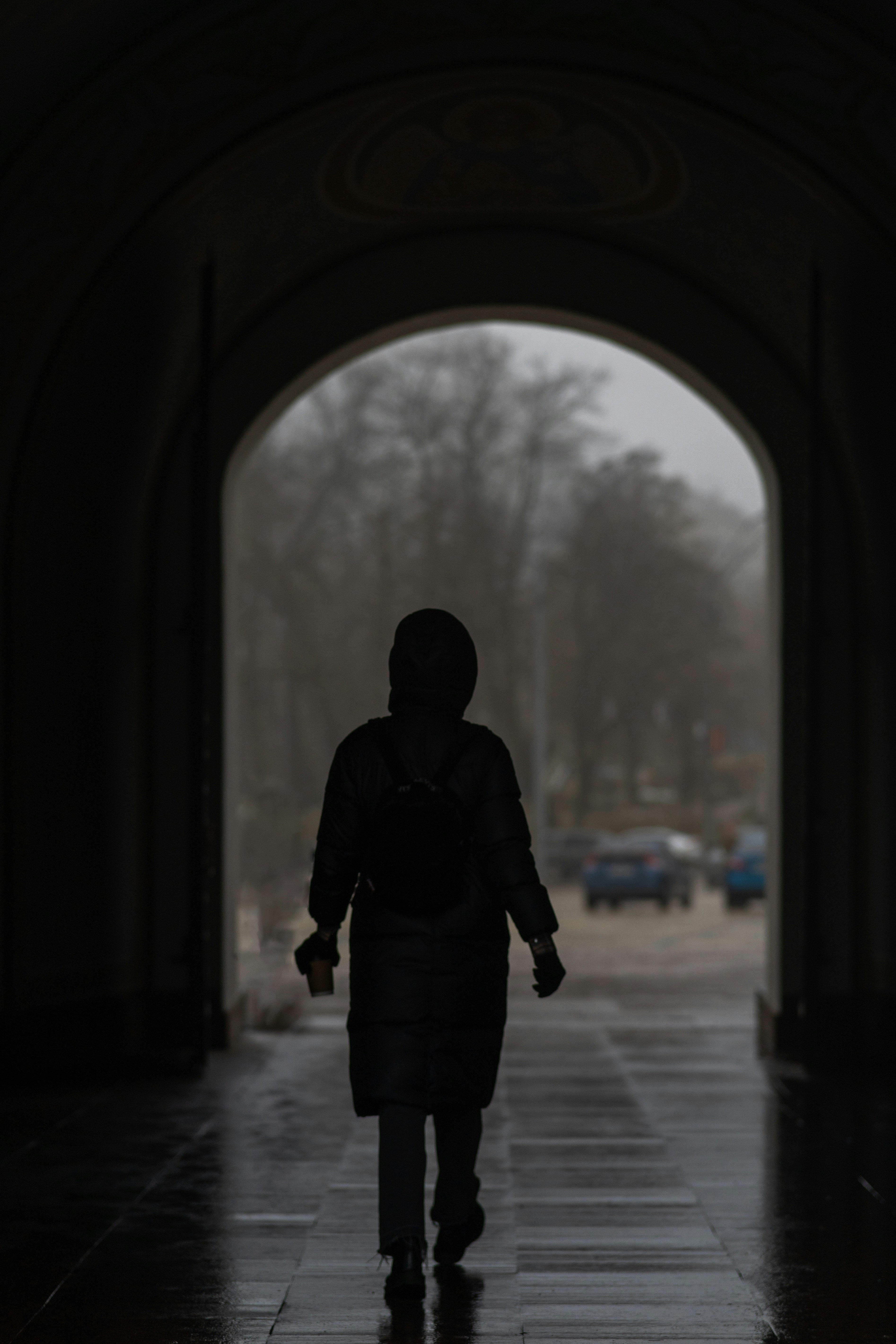 A person walking down a sidewalk in the rain