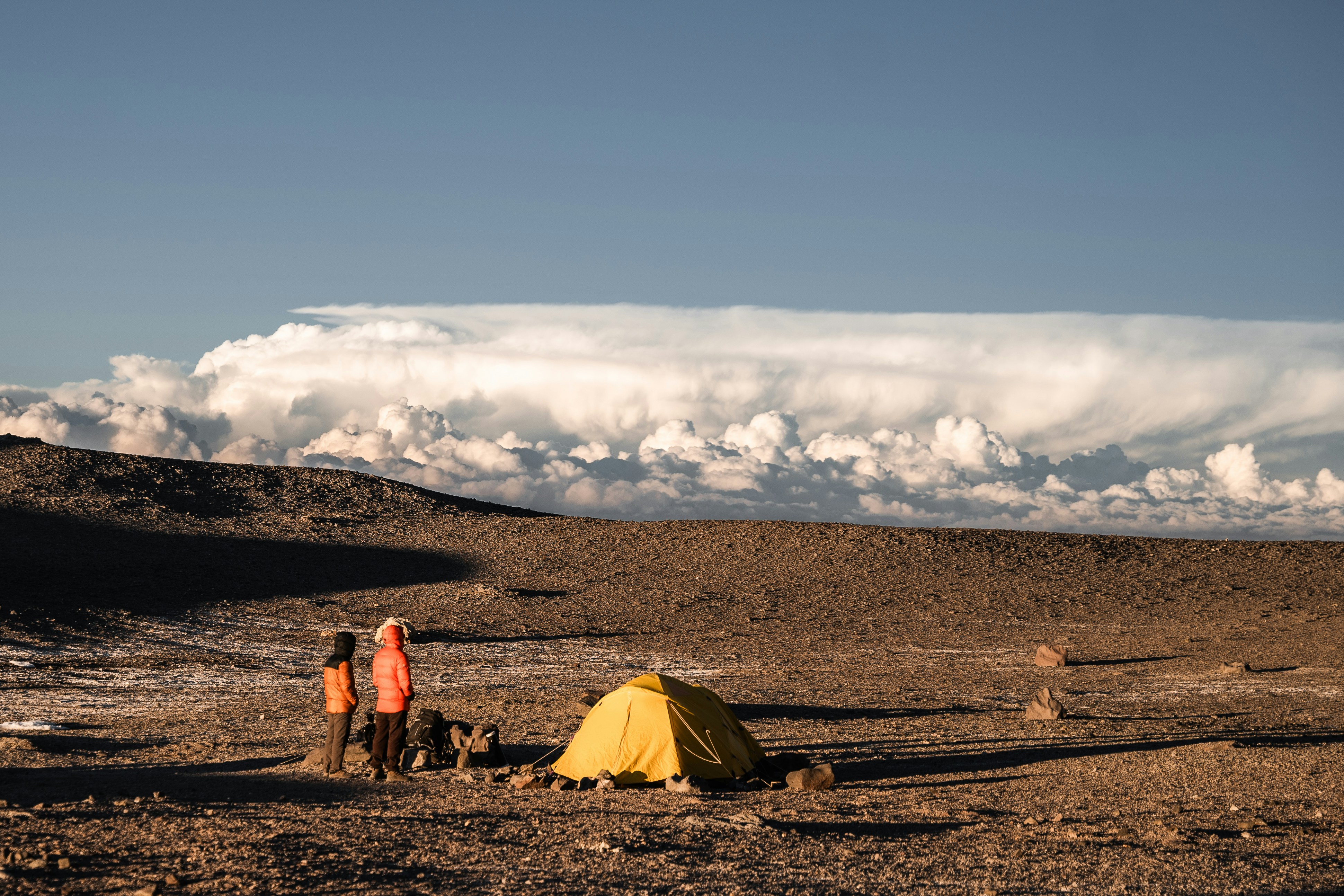 A couple of people standing next to a tent