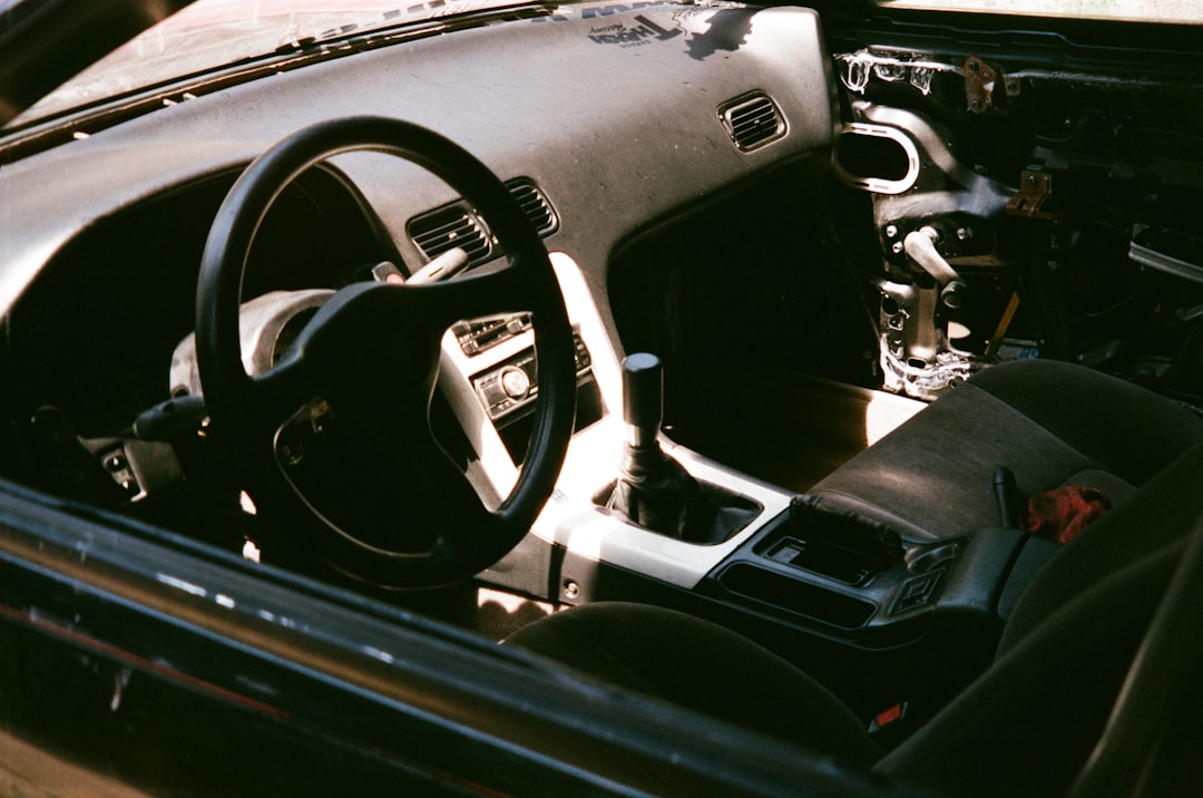 The interior of a car with a steering wheel and dashboard,
