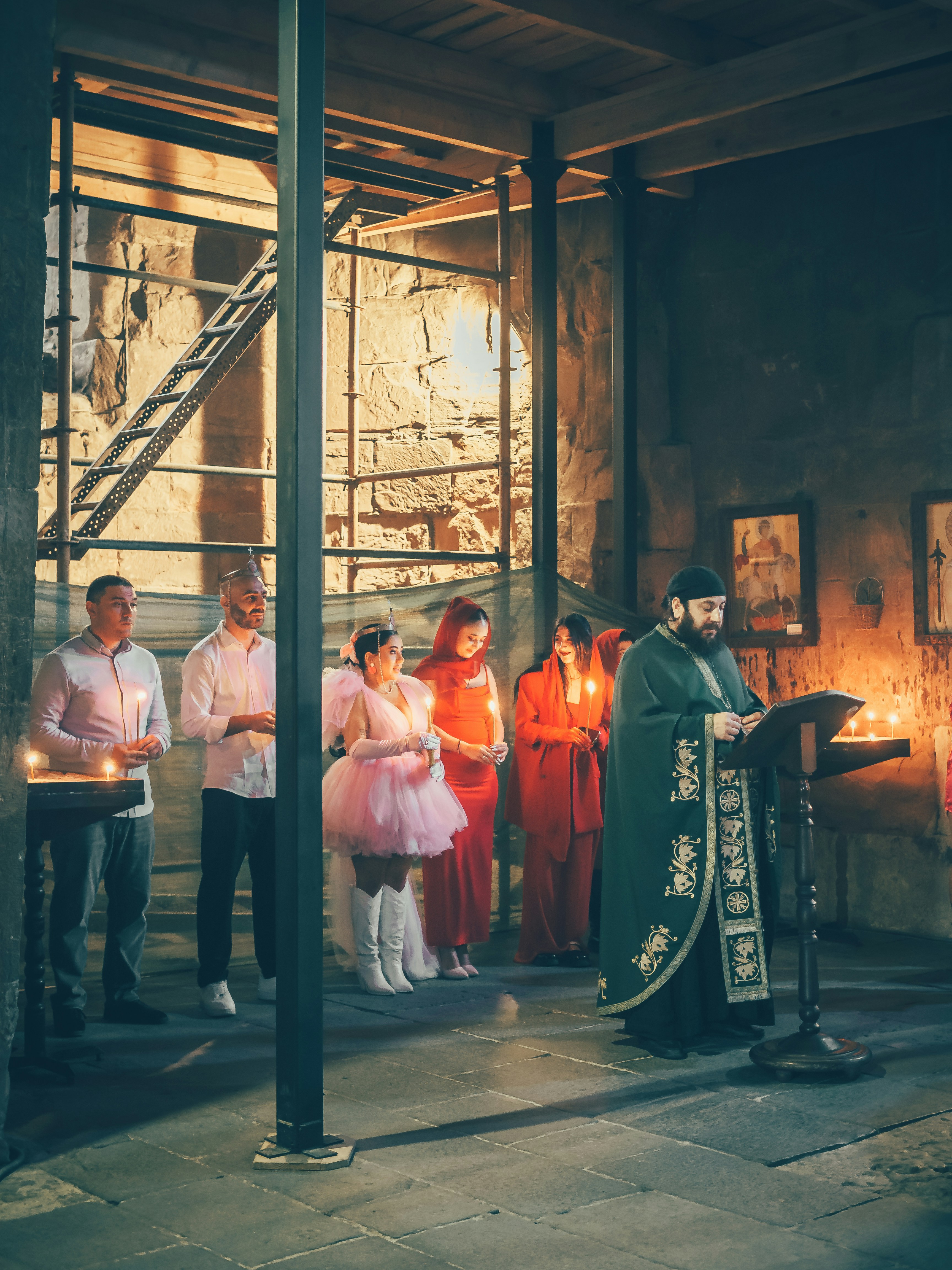 People praying together in a dimly lit church with candles on the altar