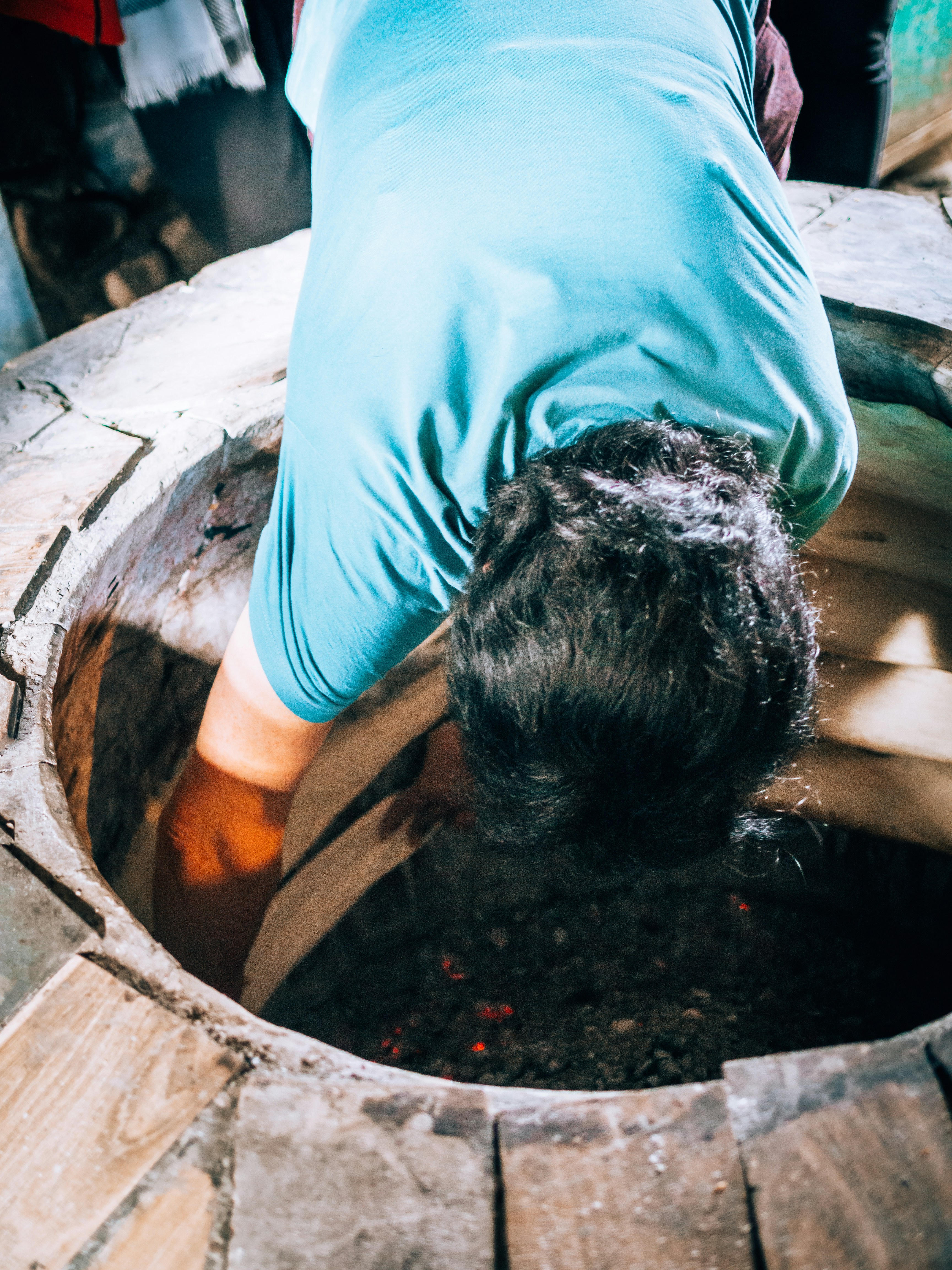 Eine Person, die sich in einem Metalltopf bückt