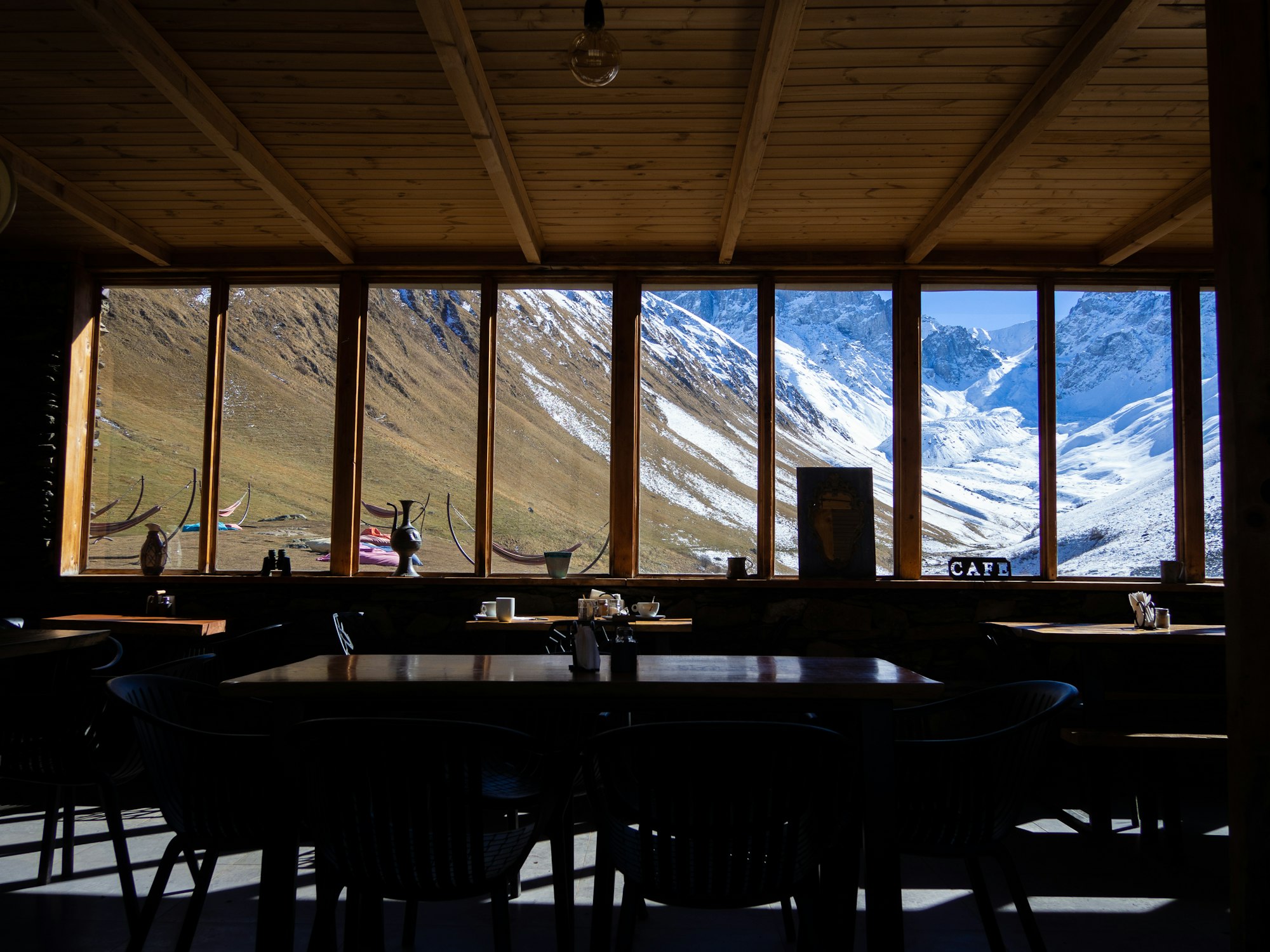 A chalet dining room looking out on the snow-covered peaks