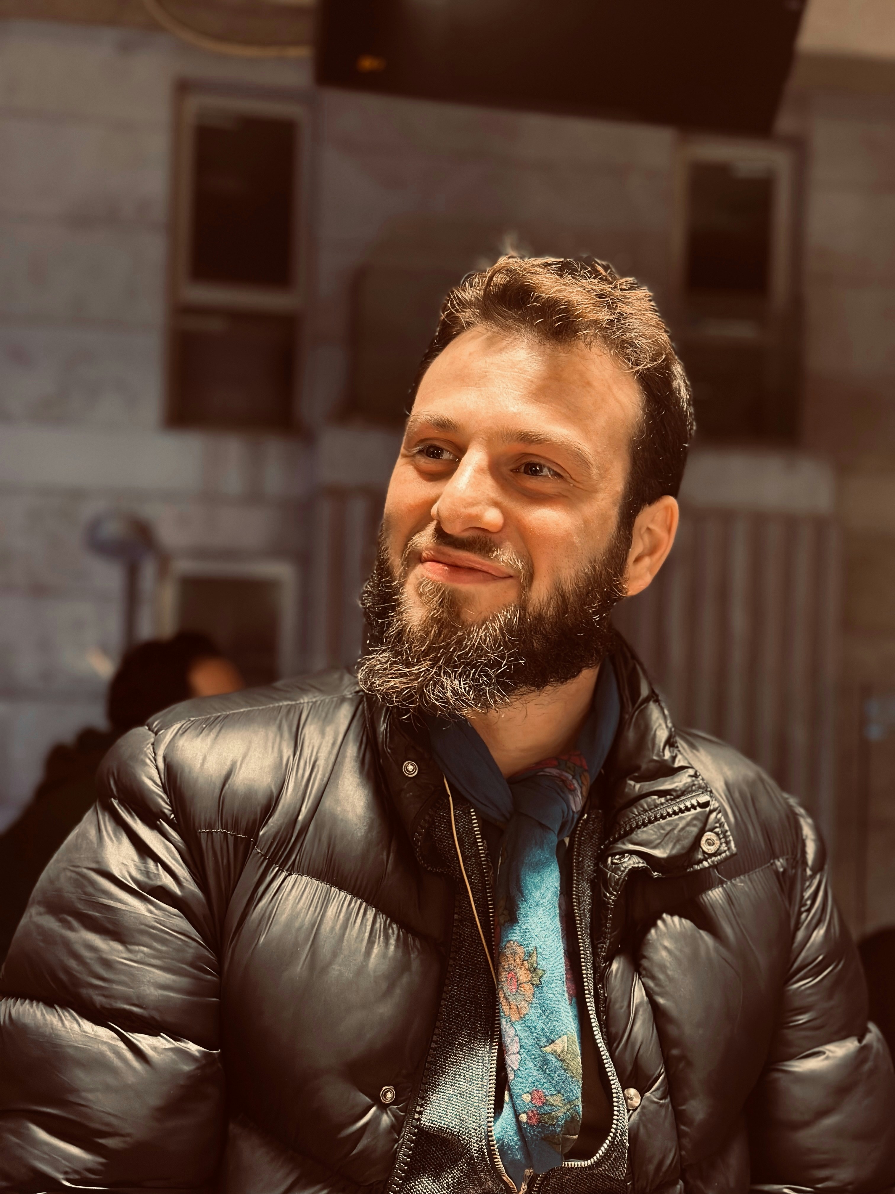 A man with a beard wearing a black jacket