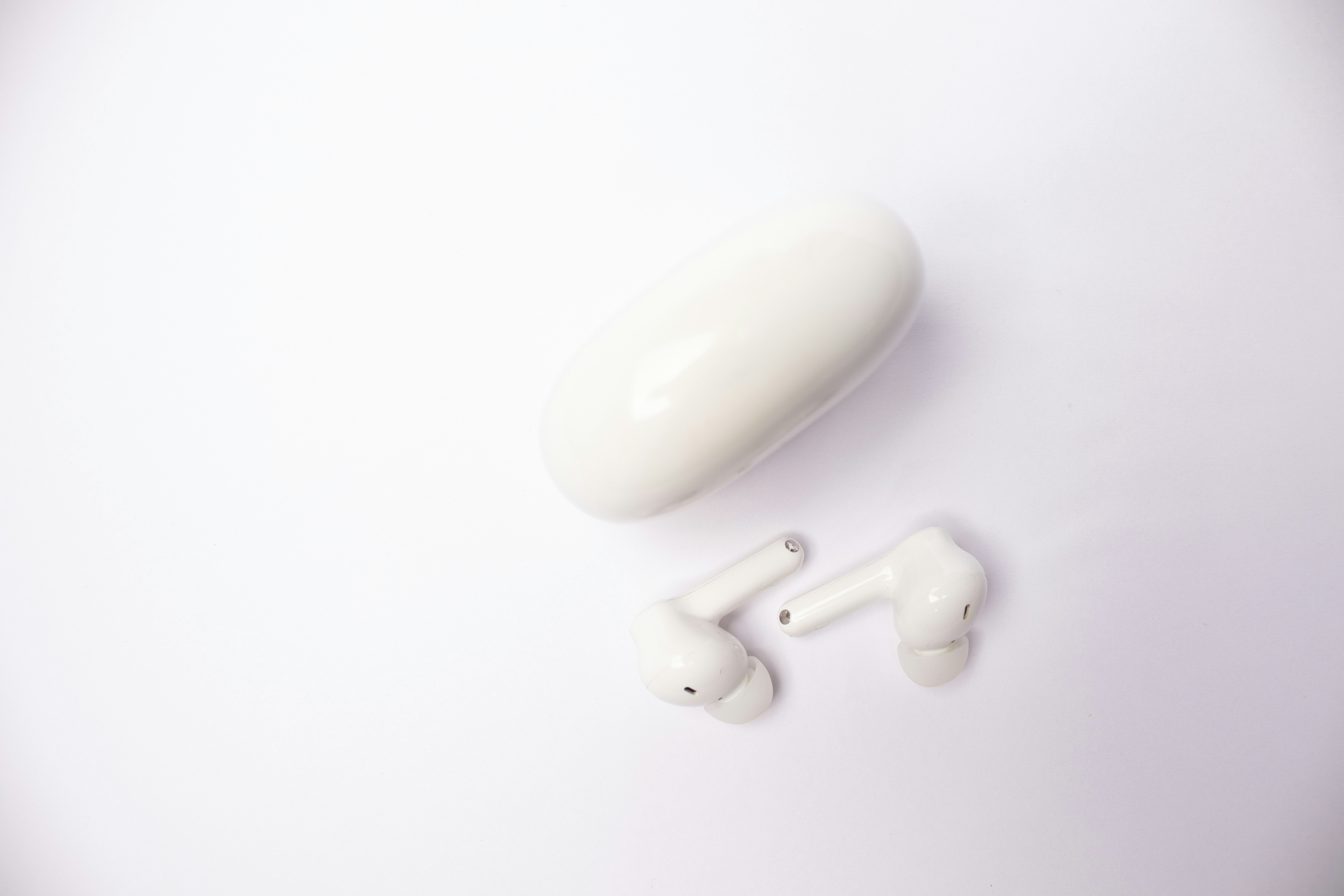 A pair of earbuds sitting on top of a white surface