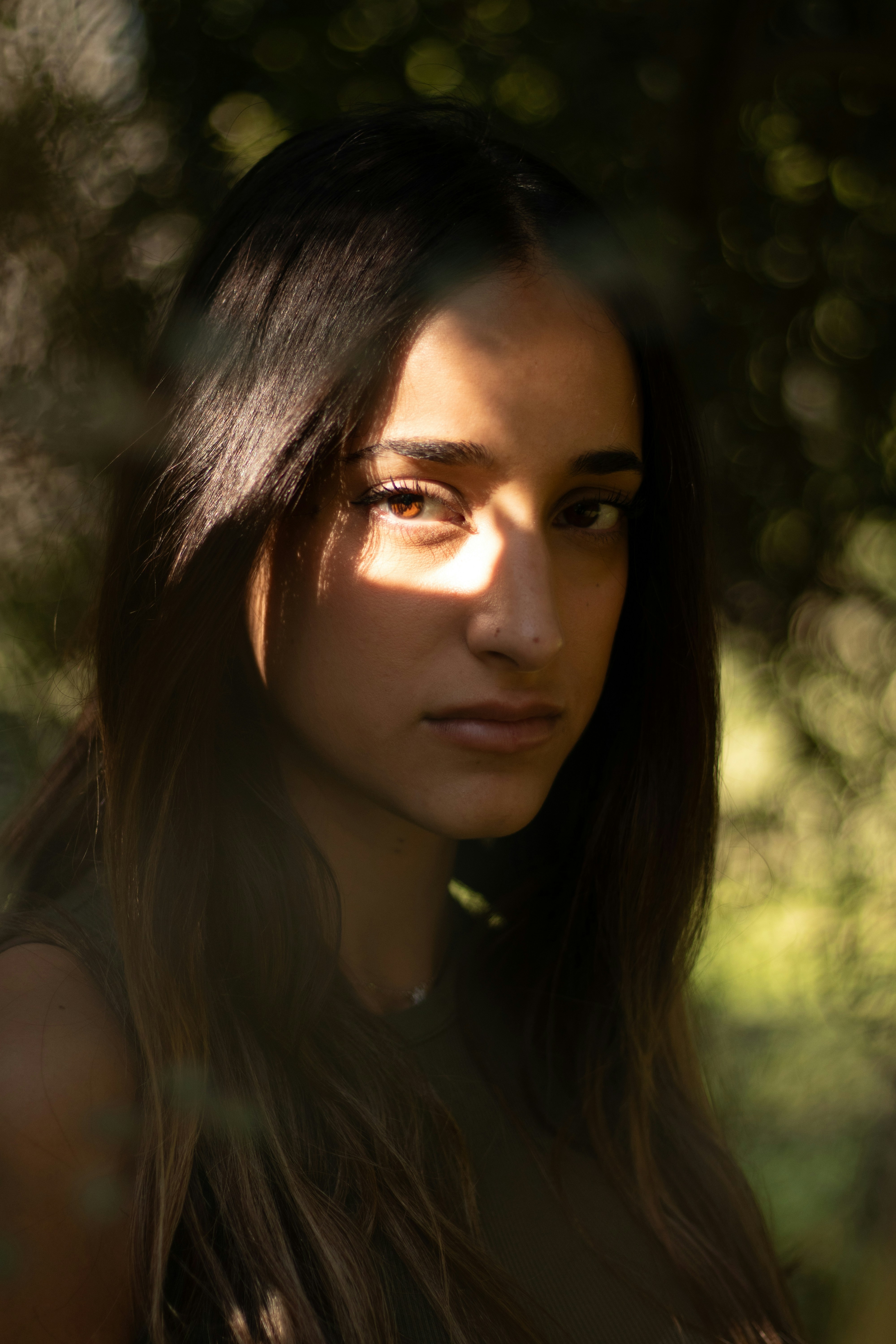 A beautiful young woman standing in front of a tree