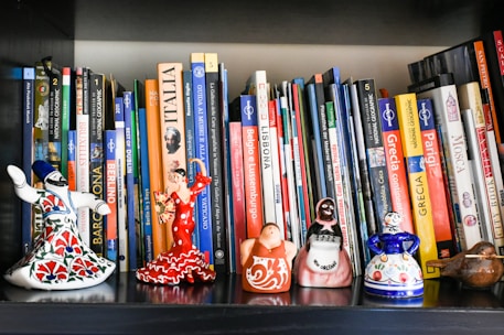 A bookshelf filled with lots of books and figurines
