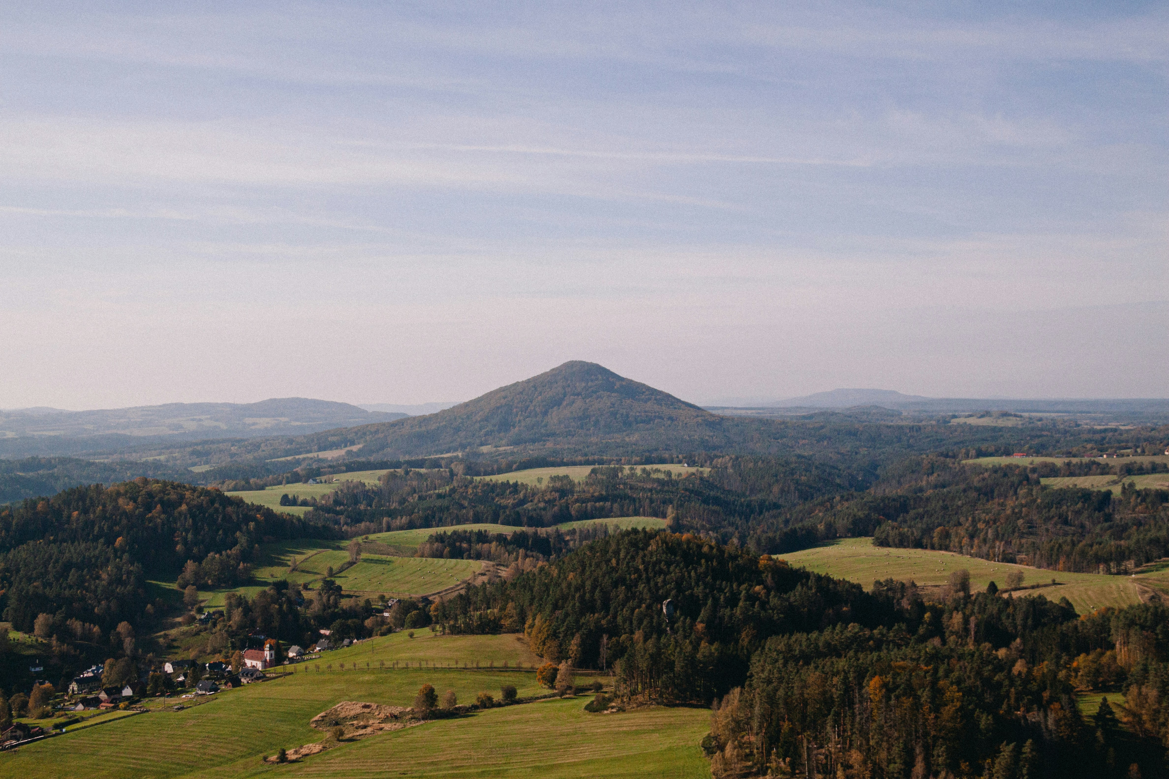 An aerial view of a valley with a mountain in the background