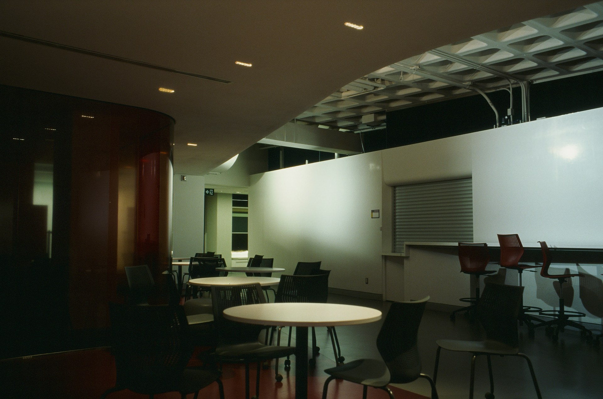A conference room with a projector screen and chairs