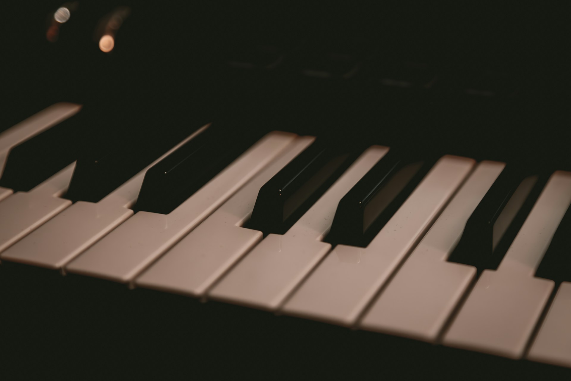 A close up of a piano keyboard in the dark