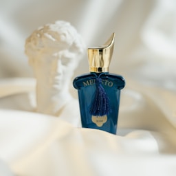 A bottle of perfume sitting on top of a bed