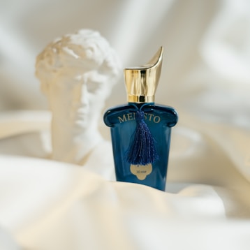A bottle of perfume sitting on top of a bed