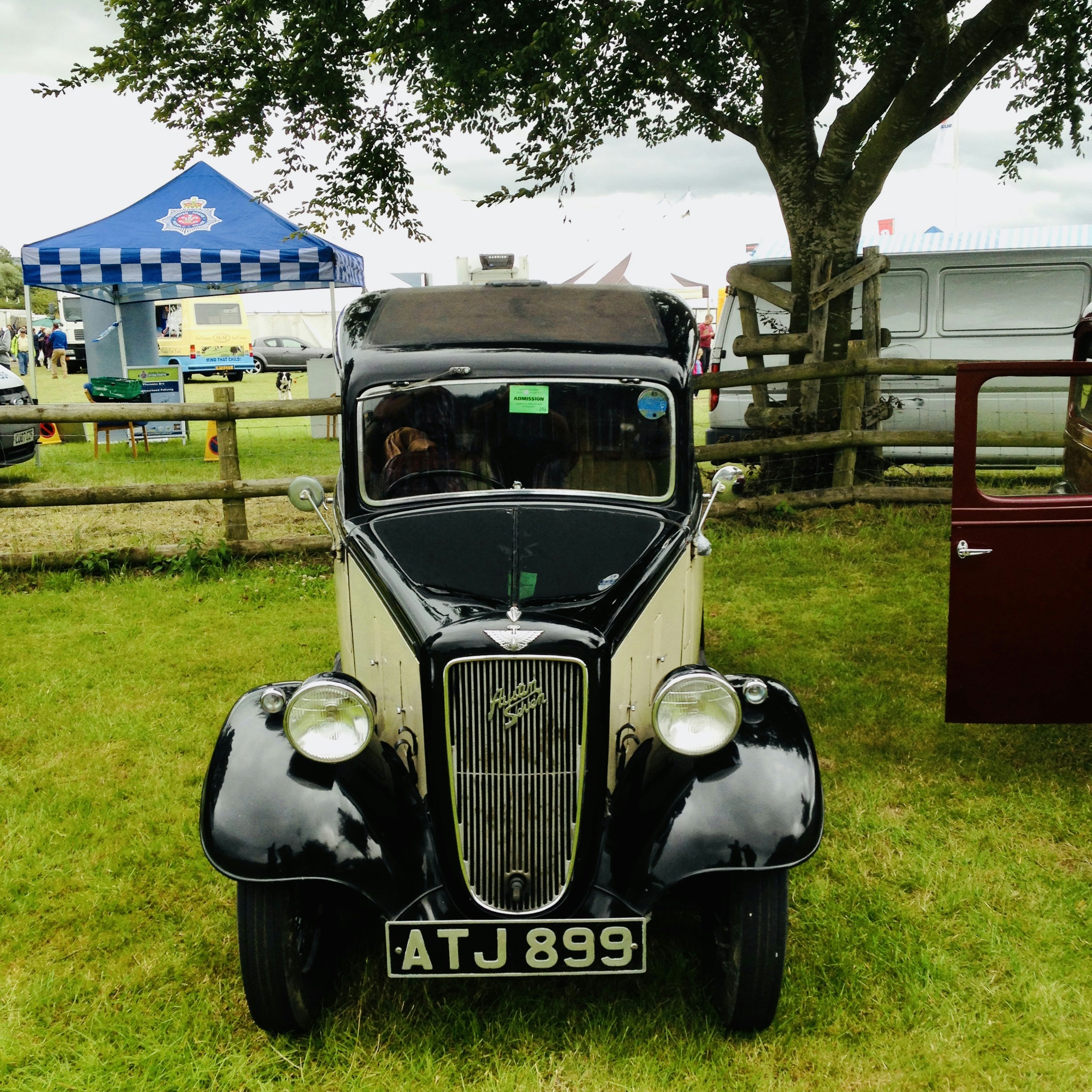 Un coche antiguo está aparcado en la hierba