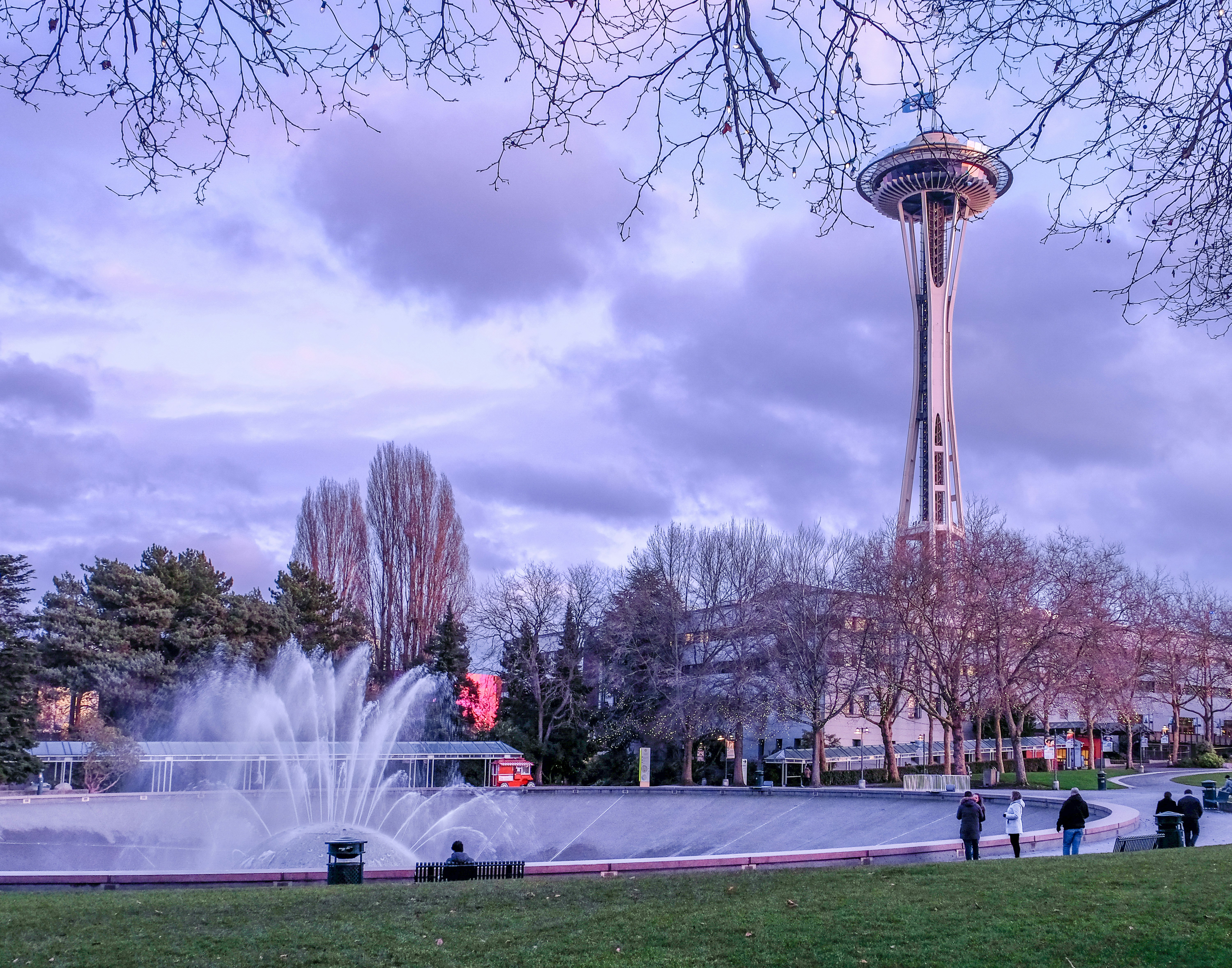 A water fountain in a park with a tower in the background