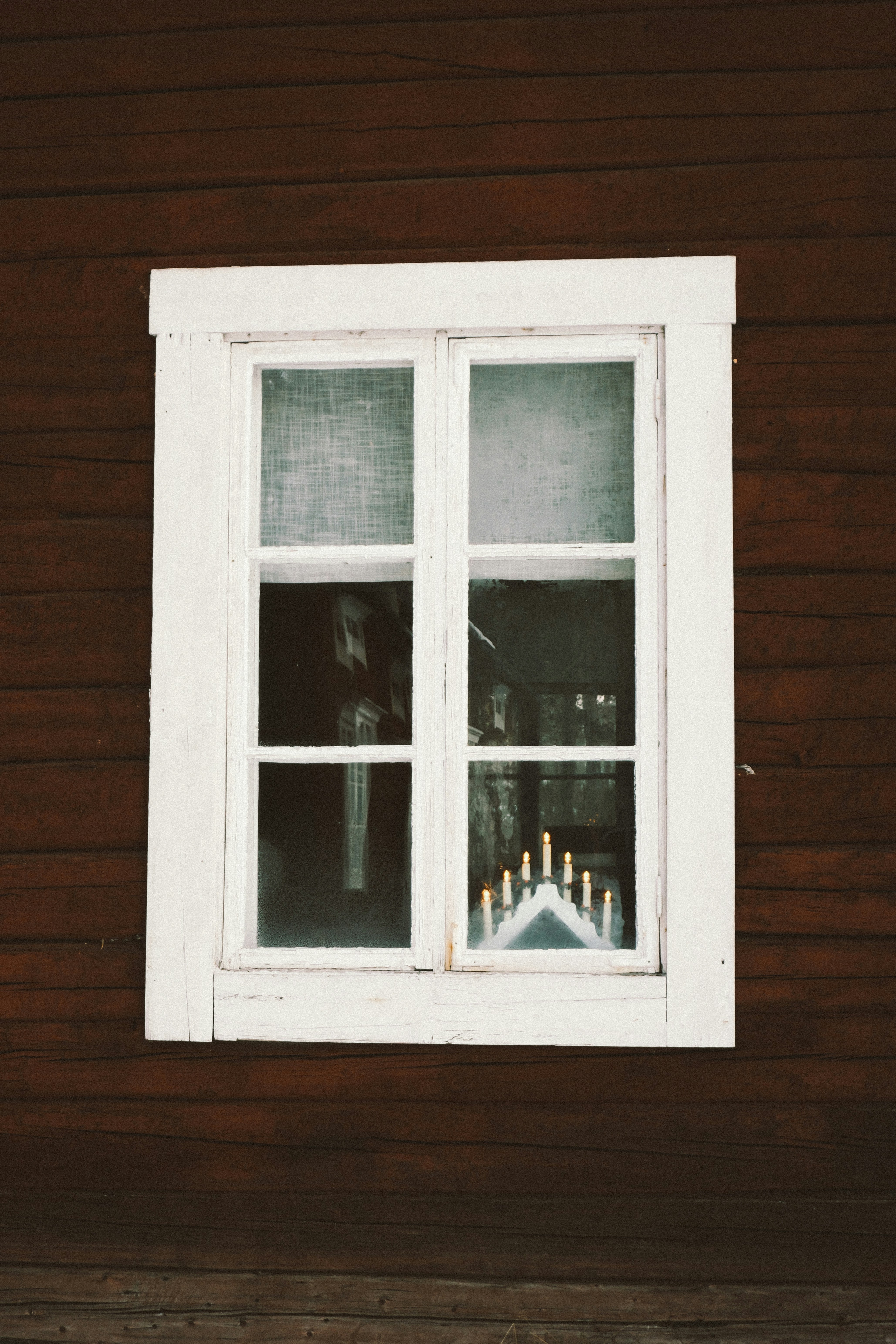 A white window with candles in the window