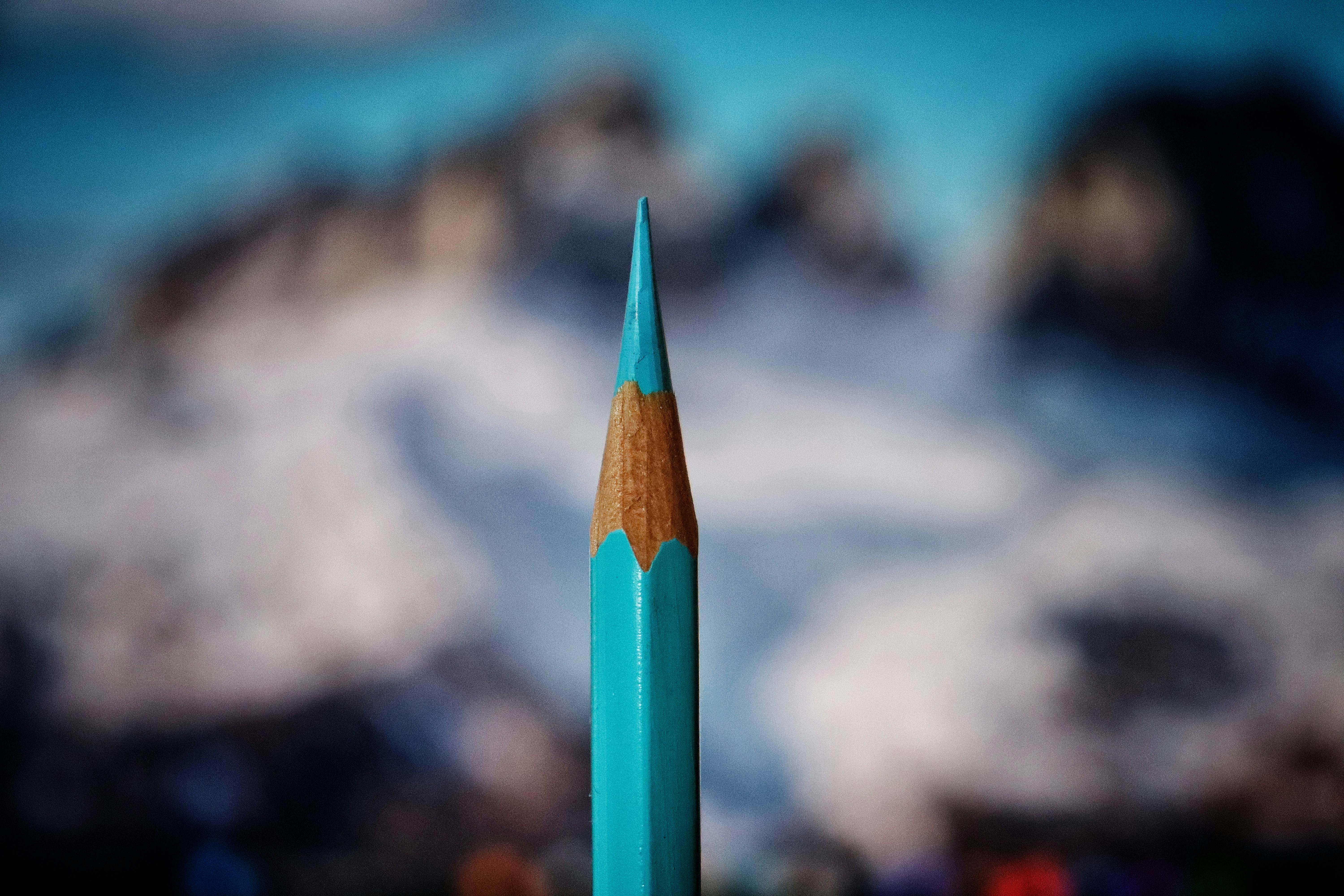 A close up of a blue pencil with a blurry background