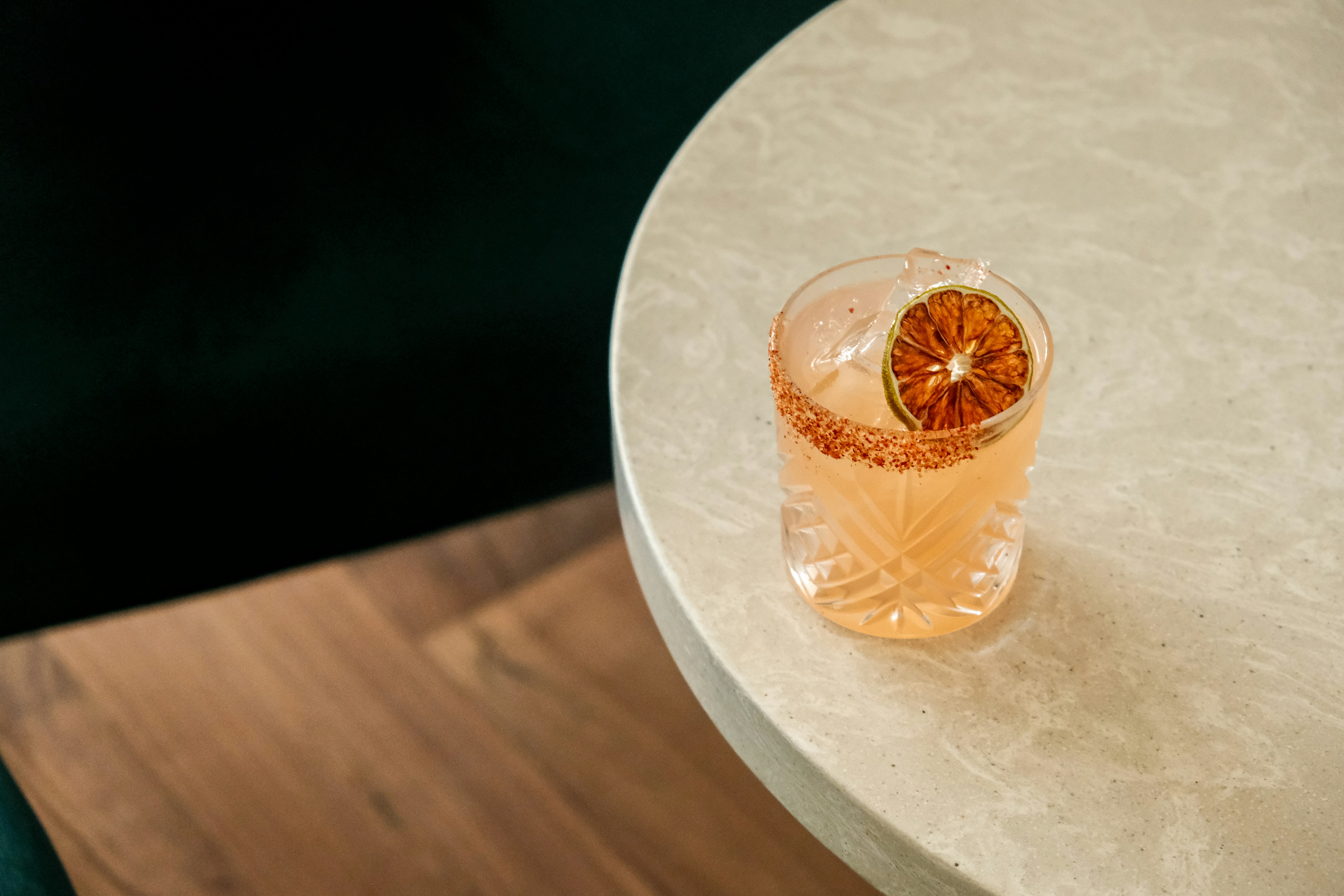 Fall Paloma with tajin rim in a rocks glass with dehydrated fruit garnish