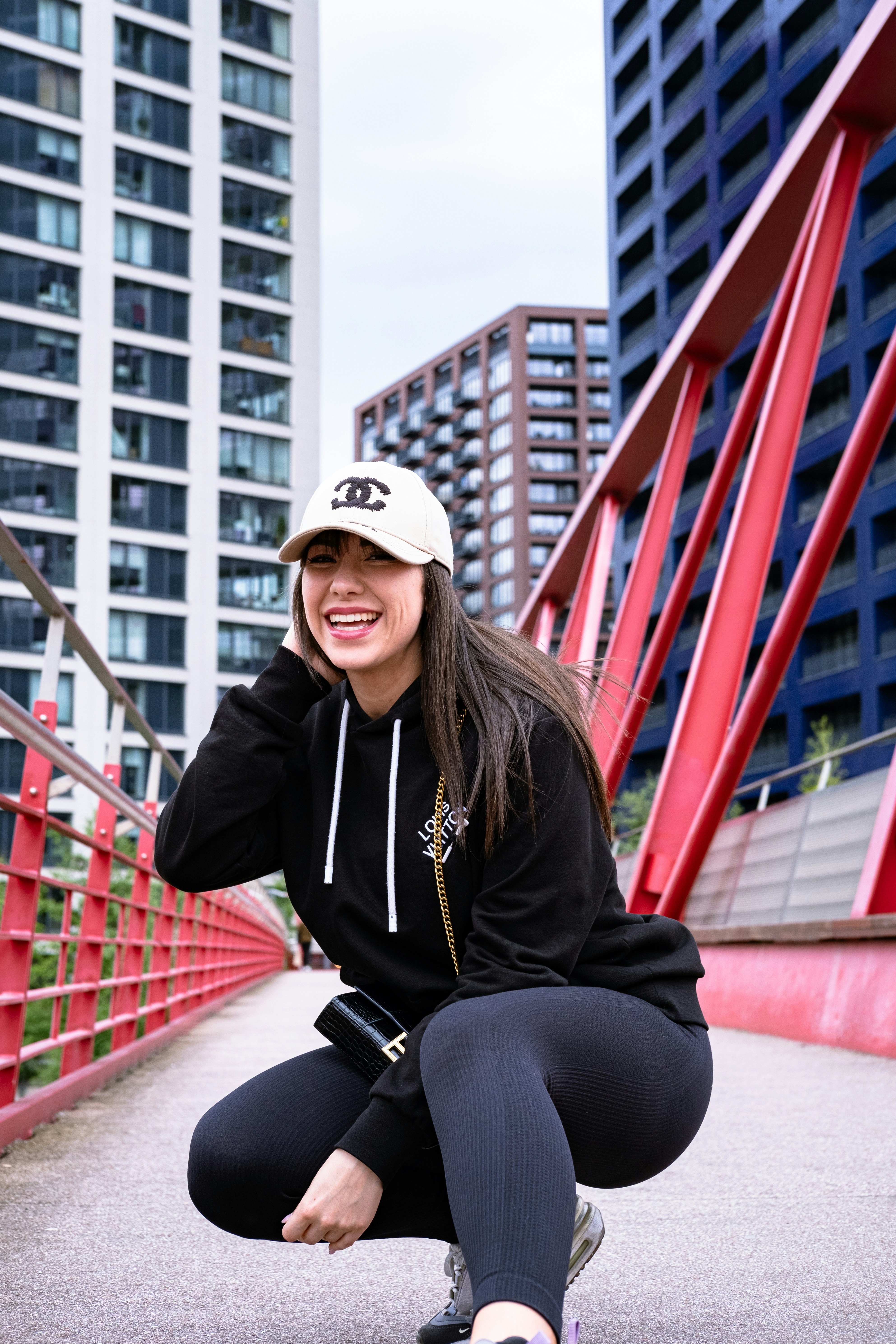 A woman kneeling down on a skateboard in a city
