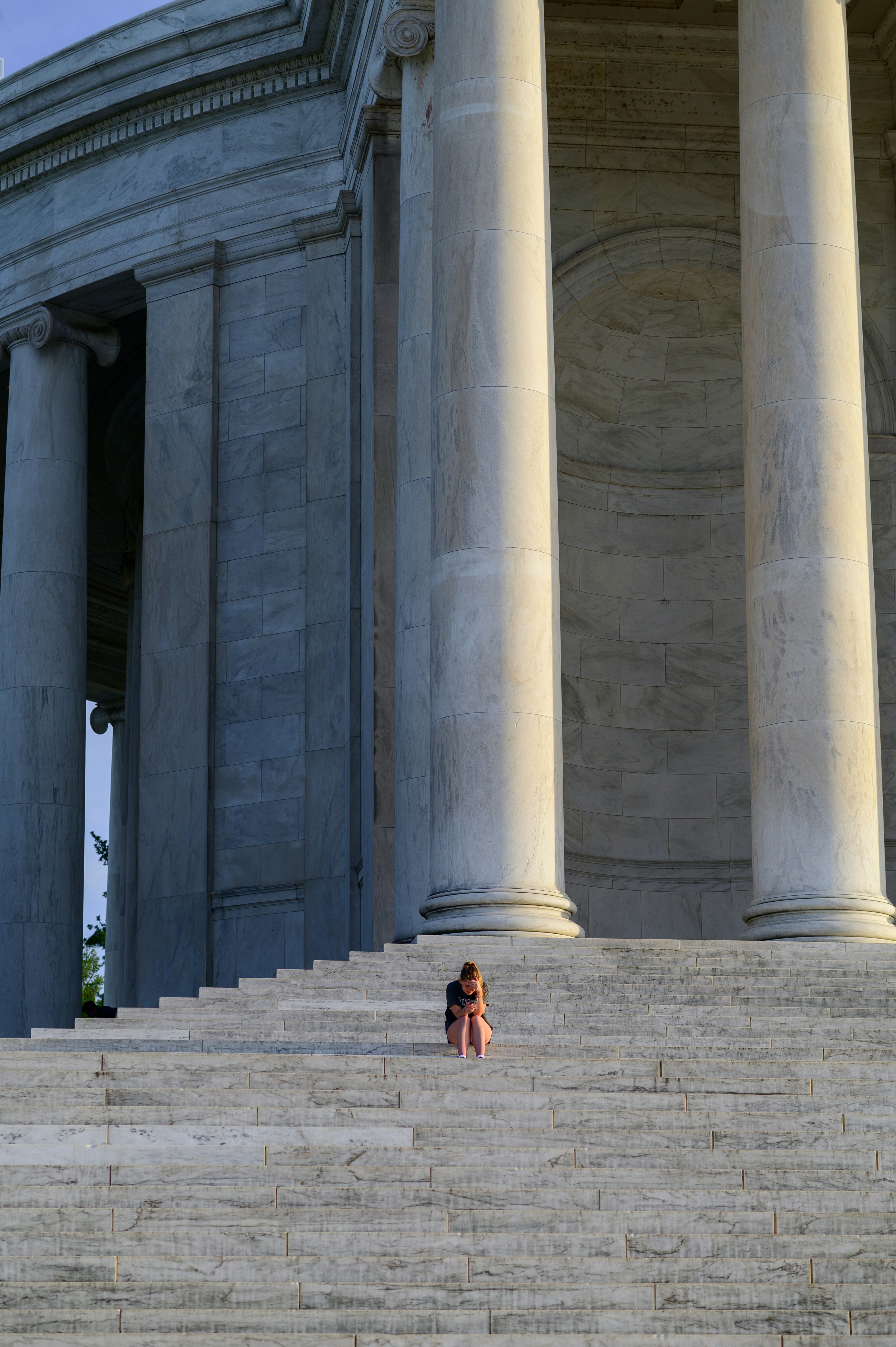 A little girl sitting on the steps of a building