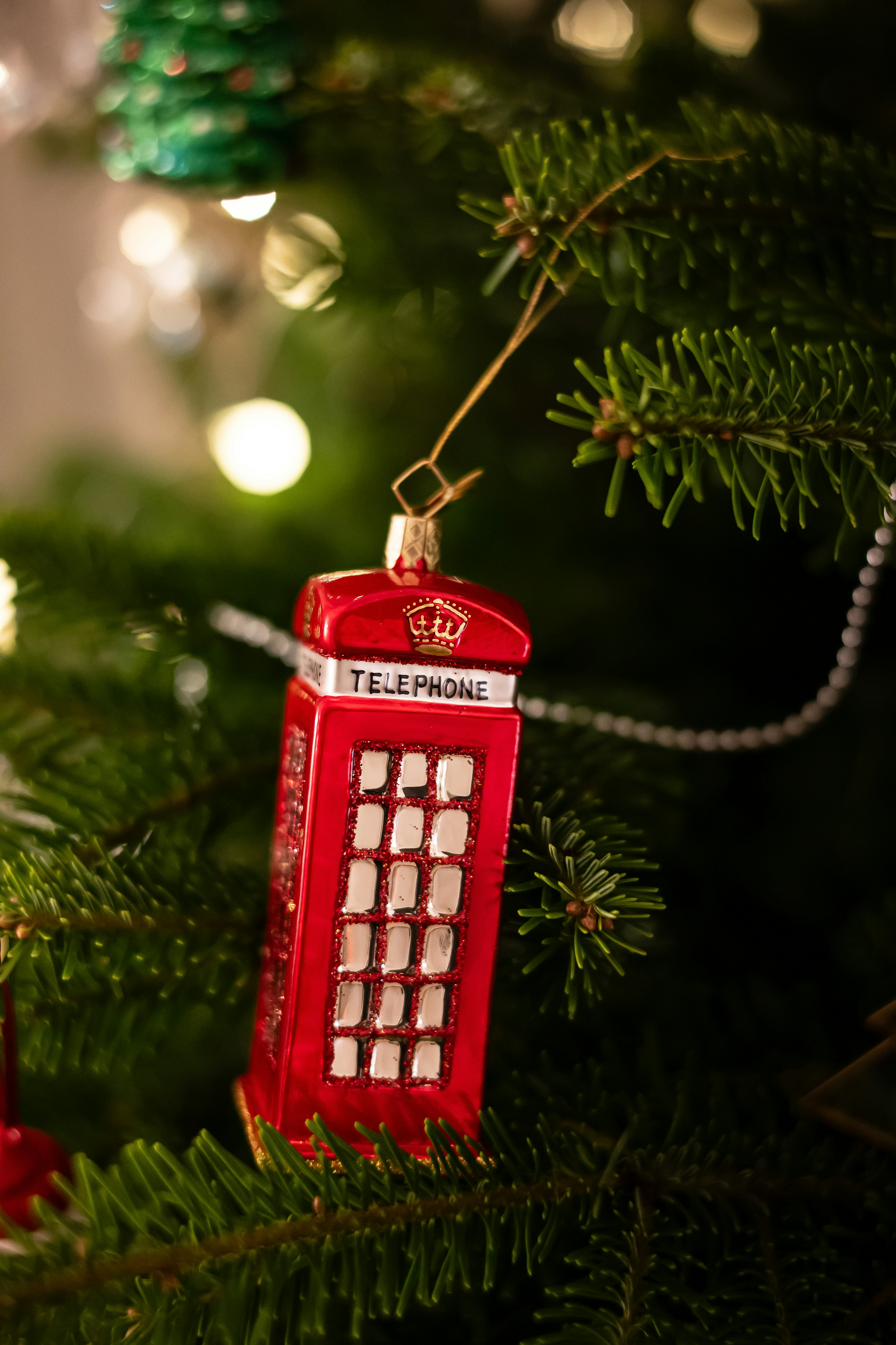 Ein roter Handyschmuck, der an einem Weihnachtsbaum hängt