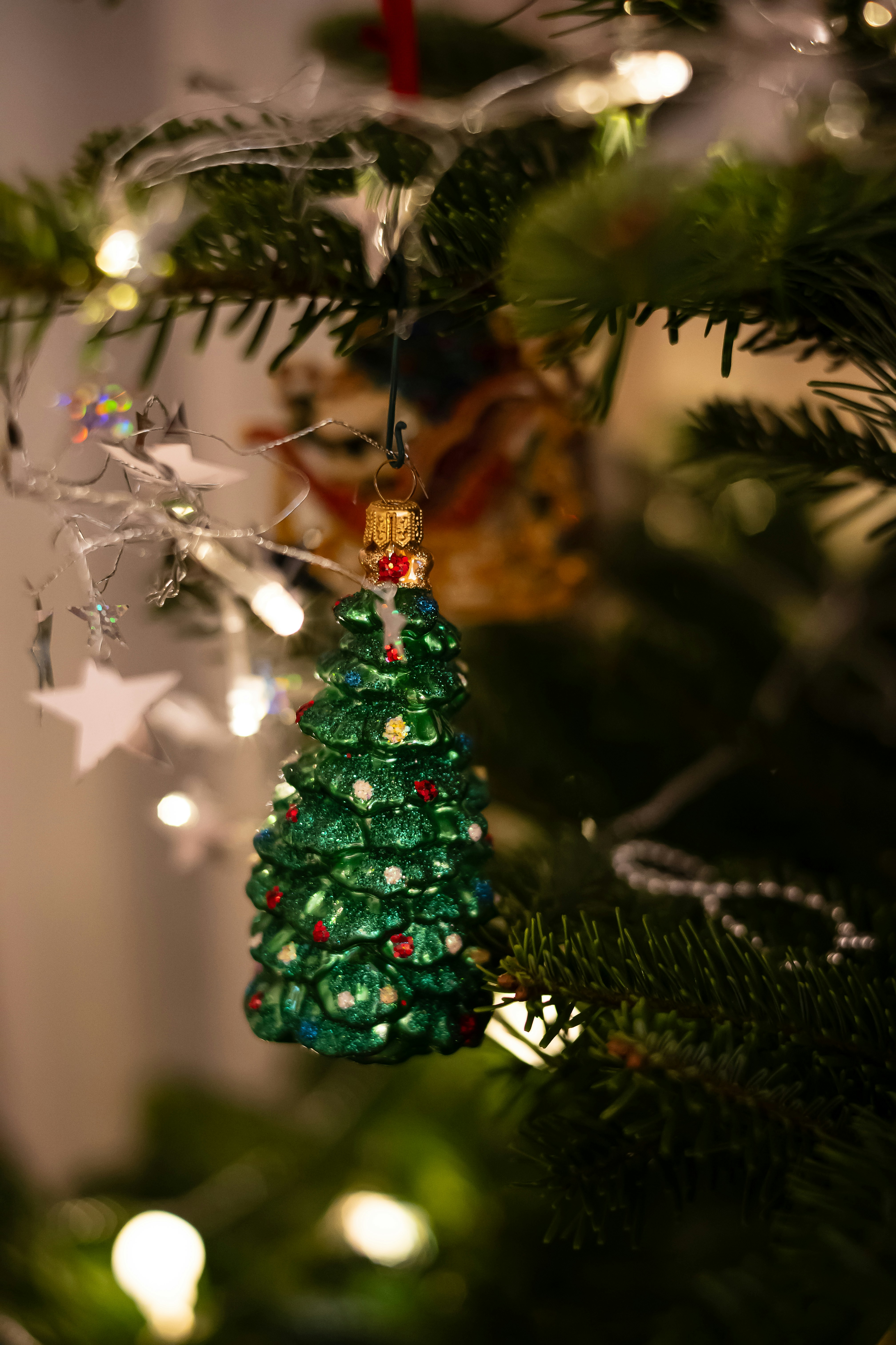 Ein grüner Christbaumschmuck, der an einem Weihnachtsbaum hängt