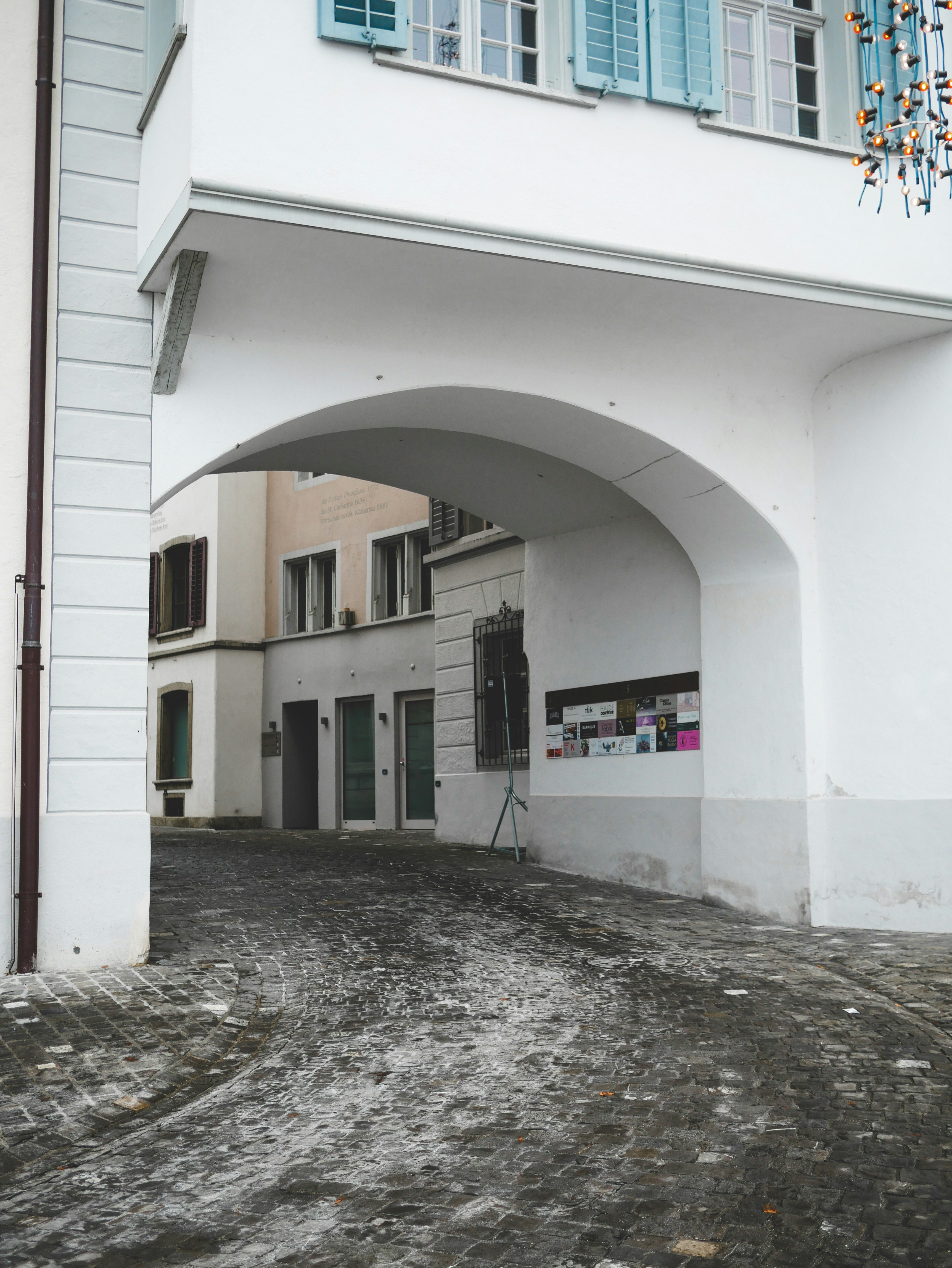 A white building with blue shutters and a red fire hydrant