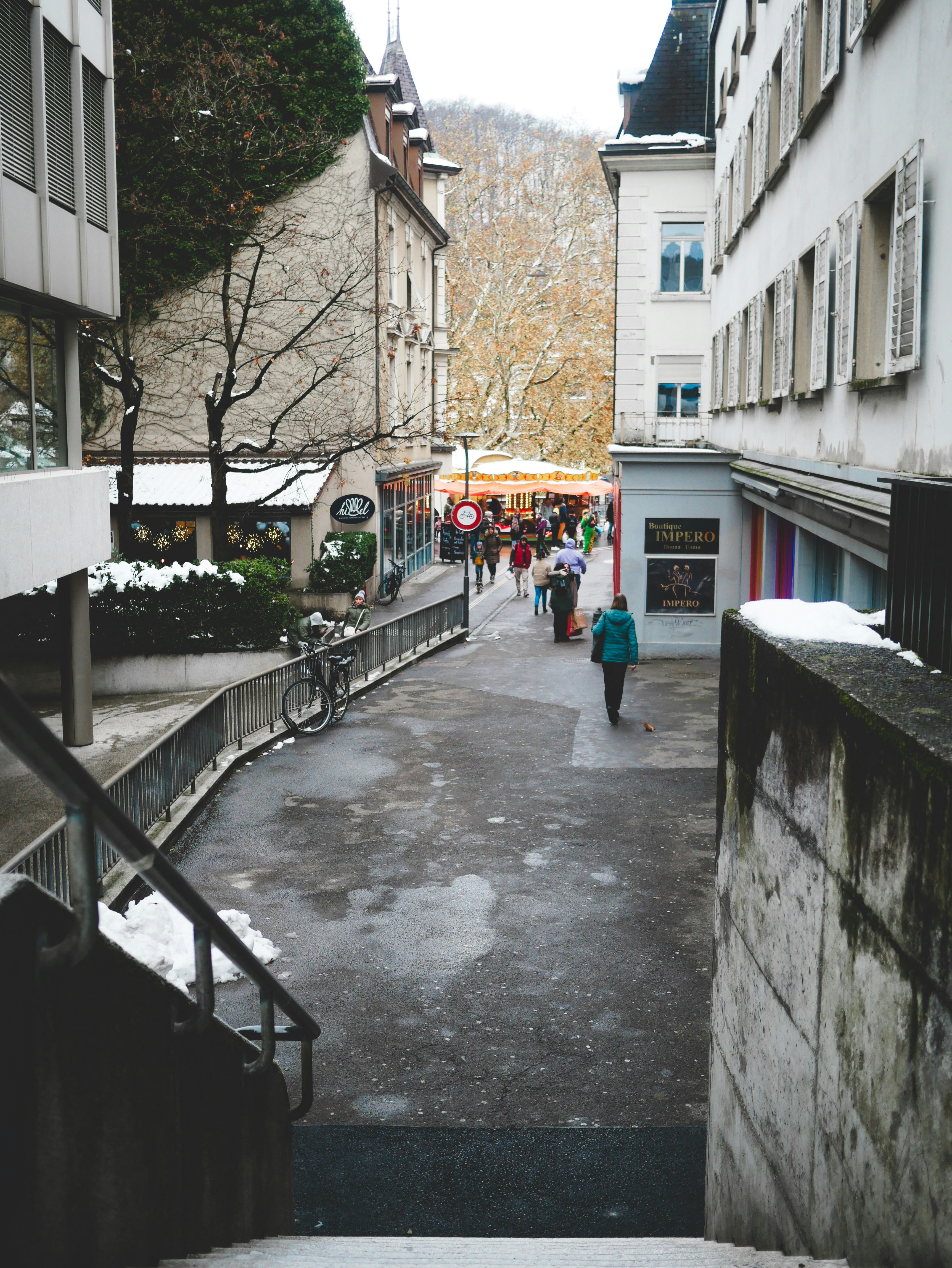A narrow street with people walking down it