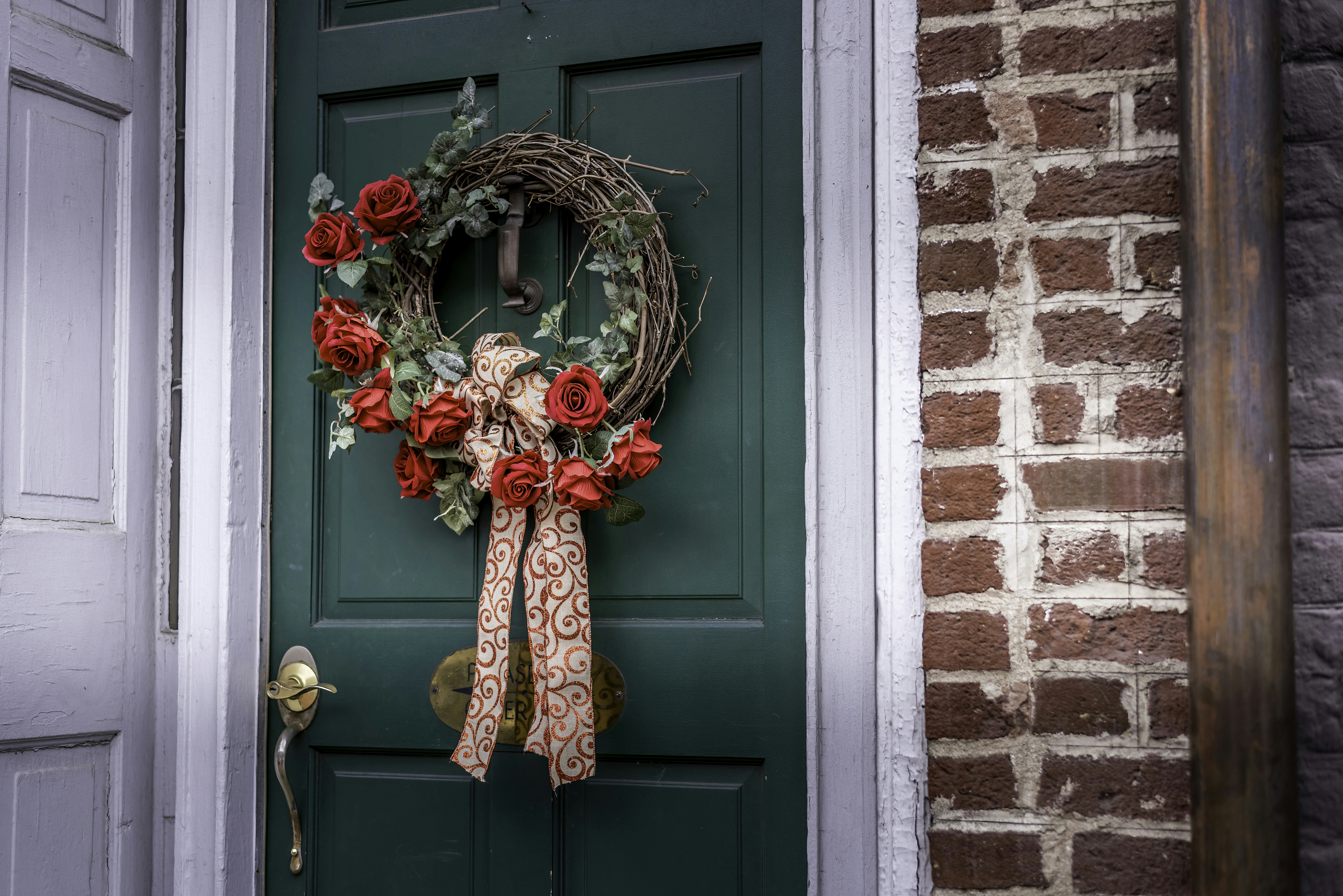 Una puerta verde con una corona de flores