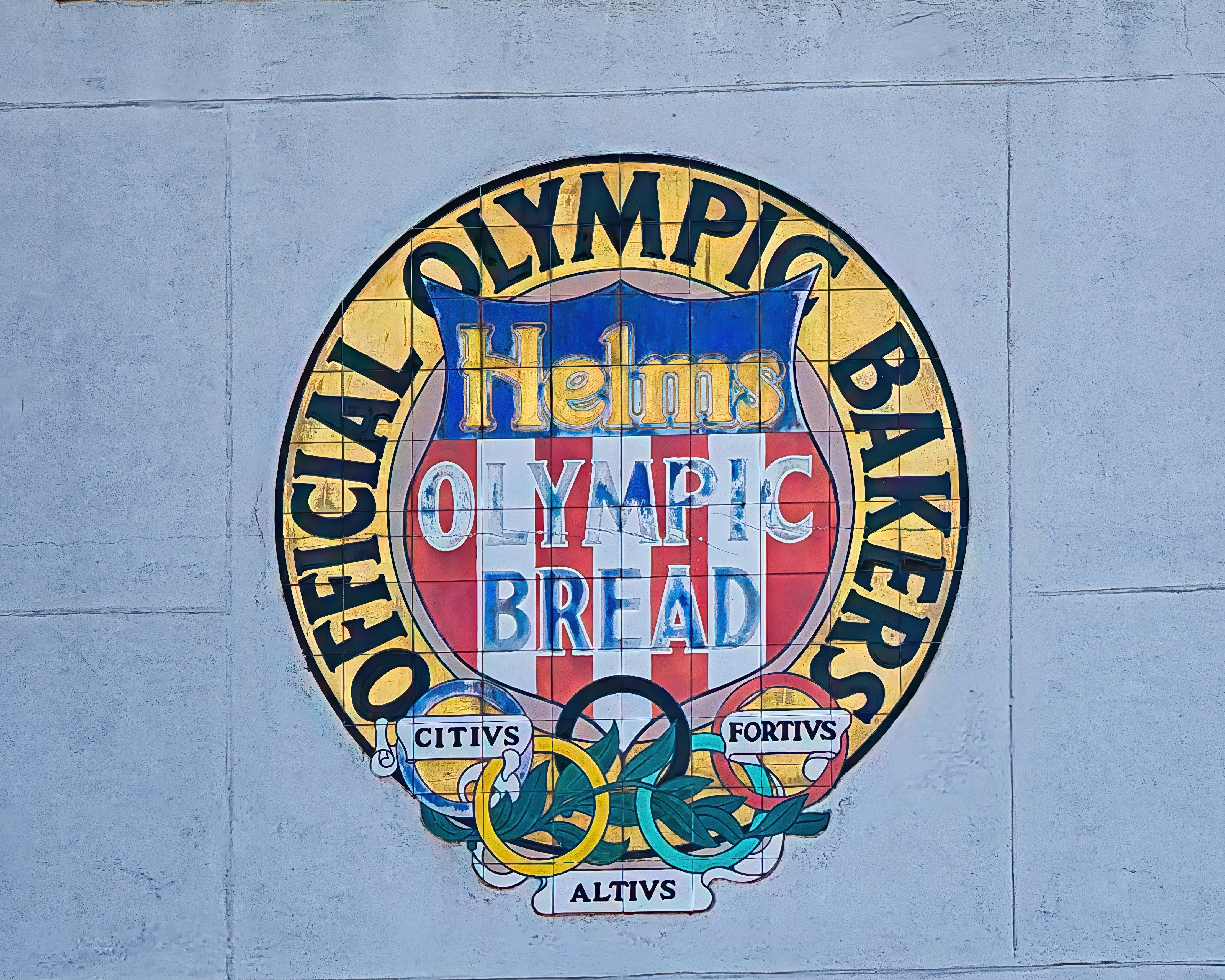 A sign on the side of a building that says olympic bread