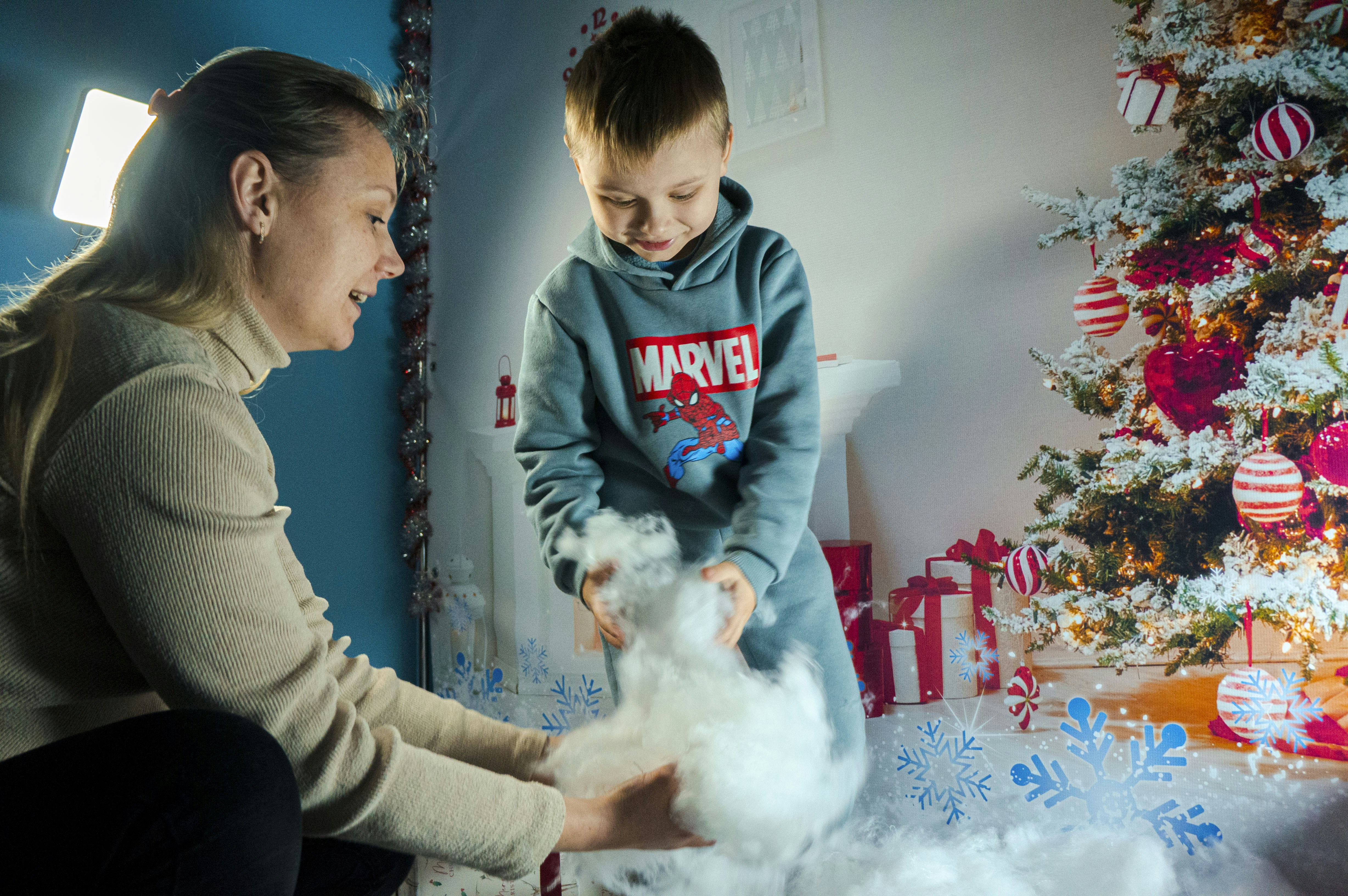 A woman and a child are decorating a christmas tree