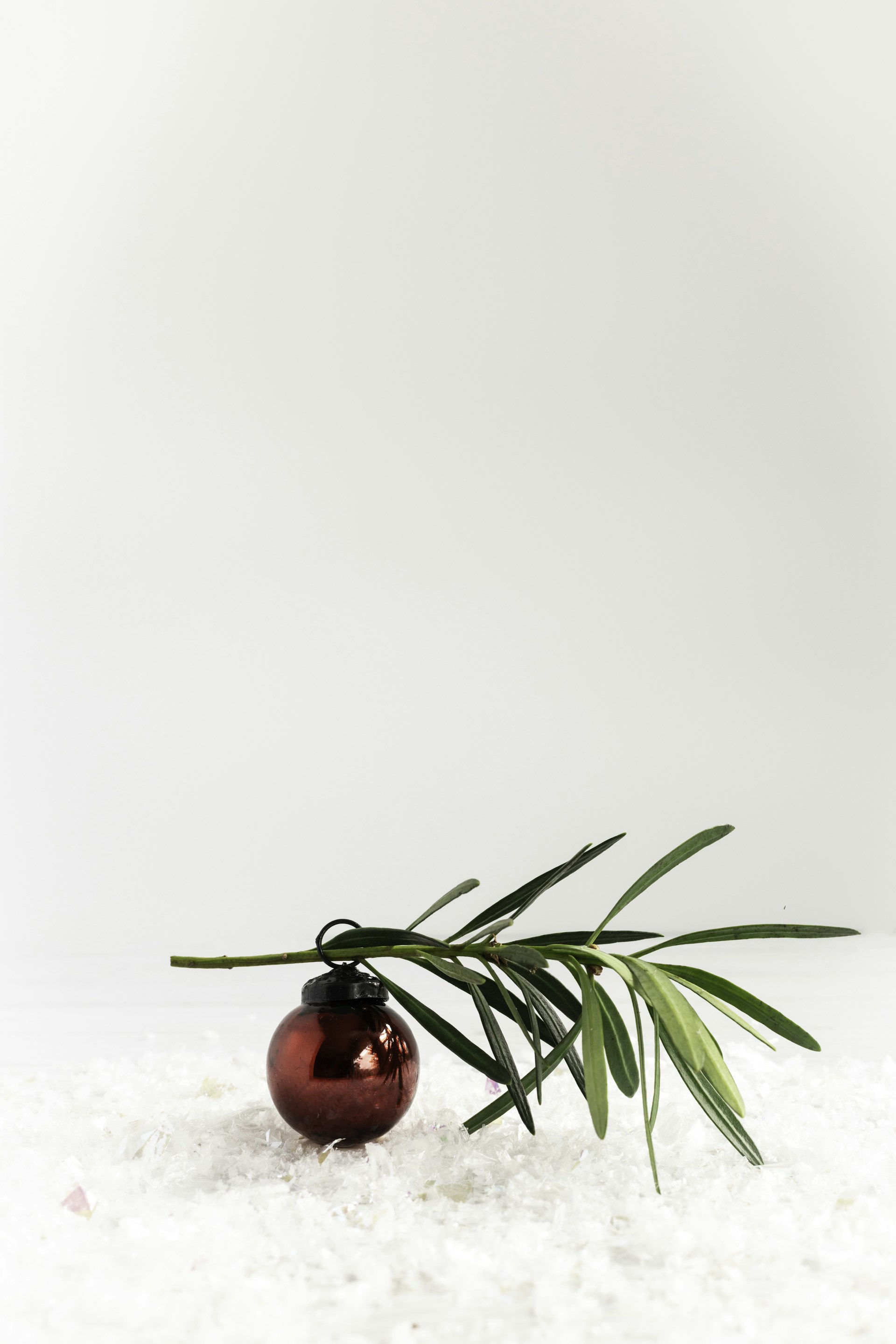 A red ornament sitting on top of a snow covered ground