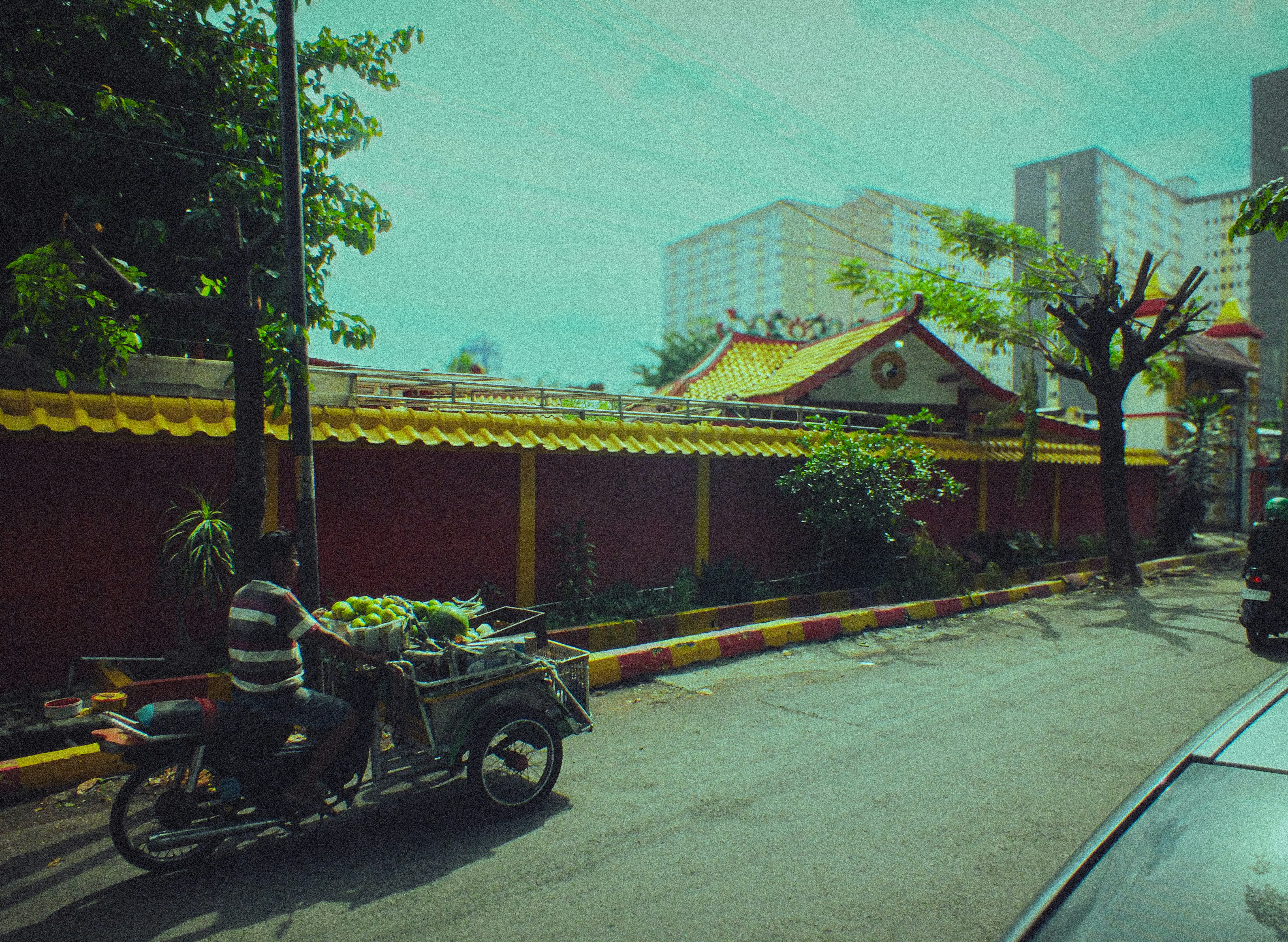 A man riding a motorcycle down a street next to tall buildings