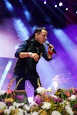 A man standing on top of a stage holding a microphone