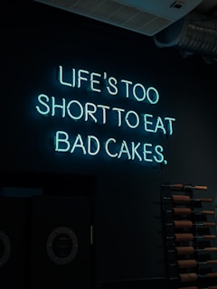 A neon sign that says life's too short to eat bad cakes