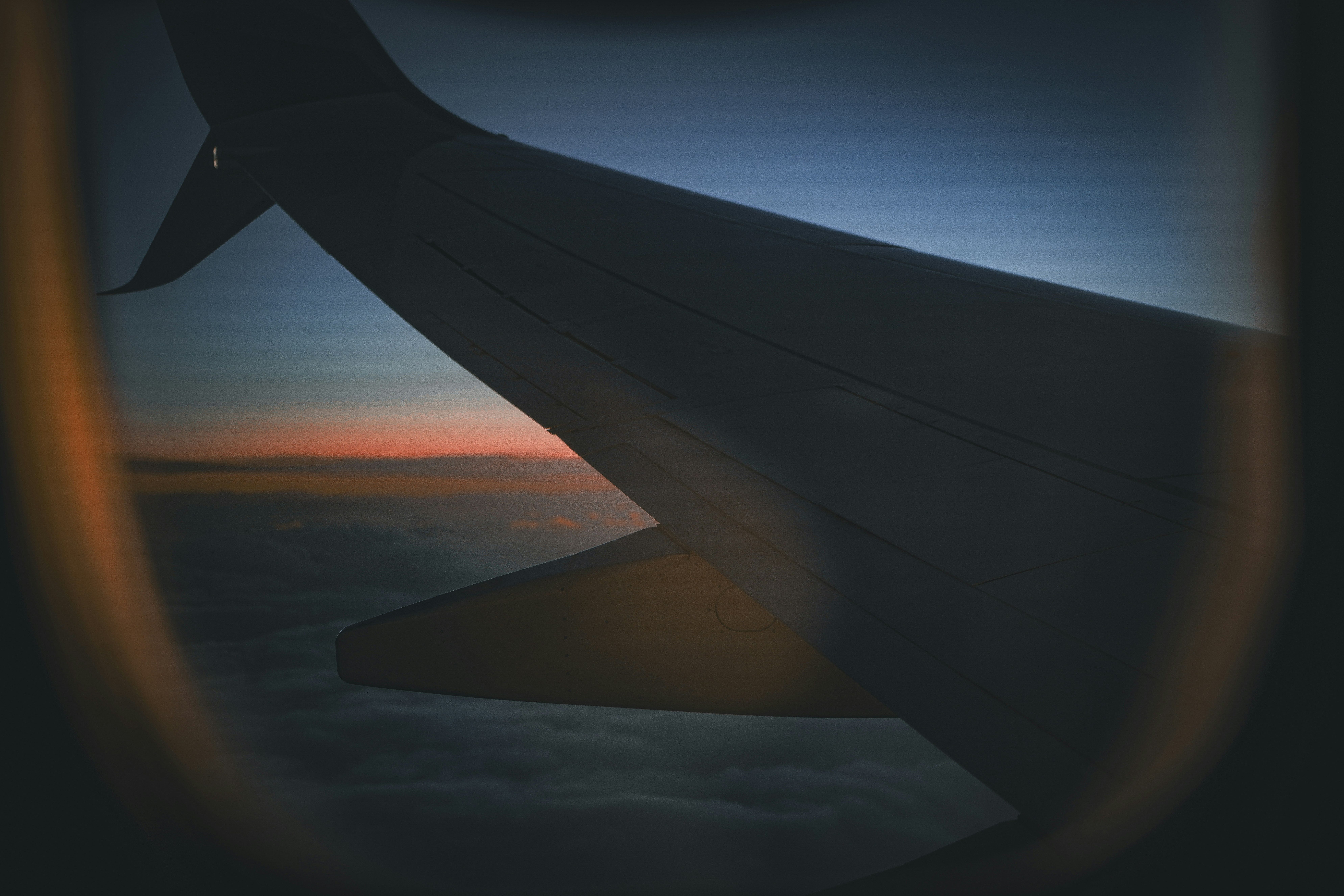 A view of the wing of an airplane at sunset
