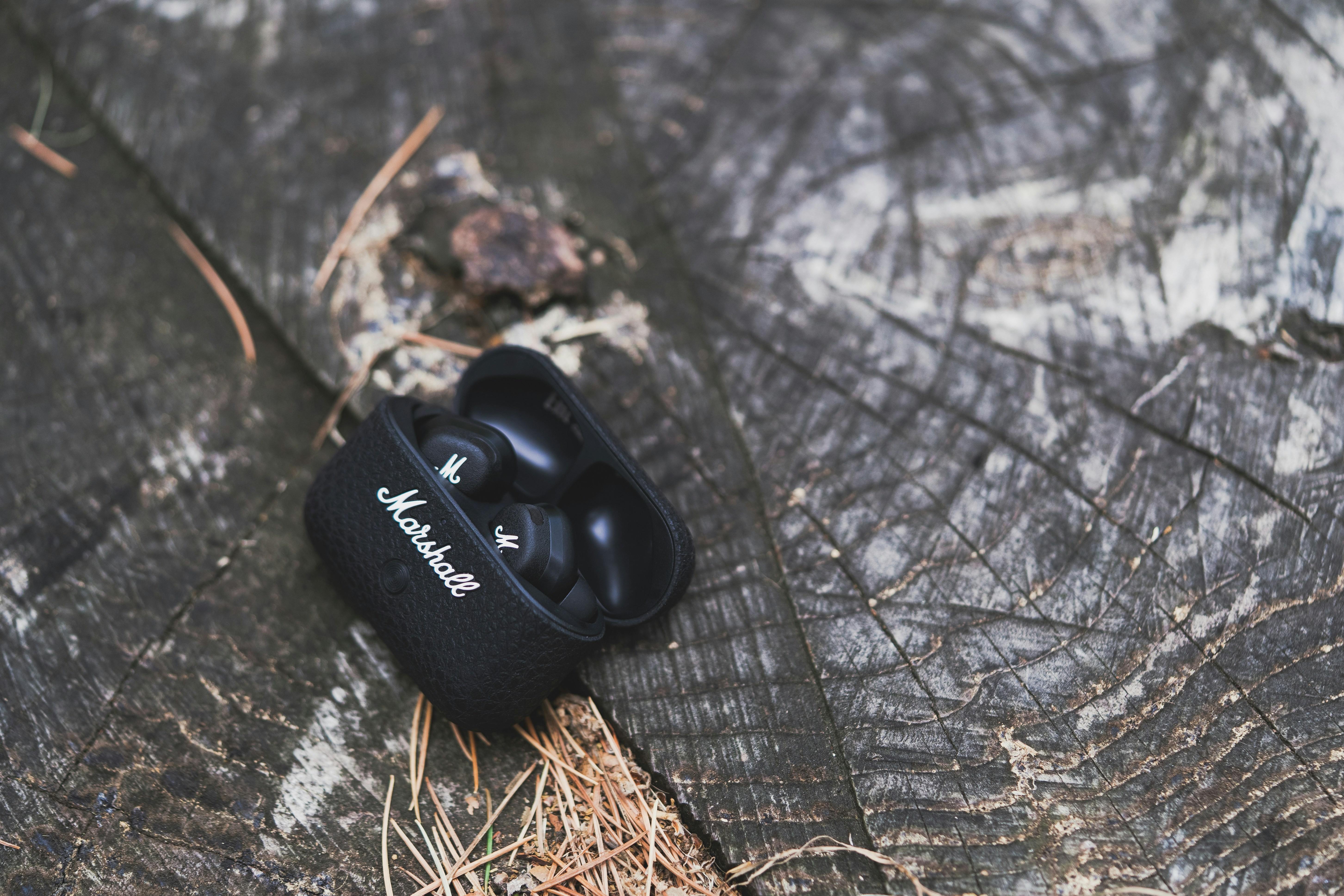 A pair of black headphones laying on a piece of wood
