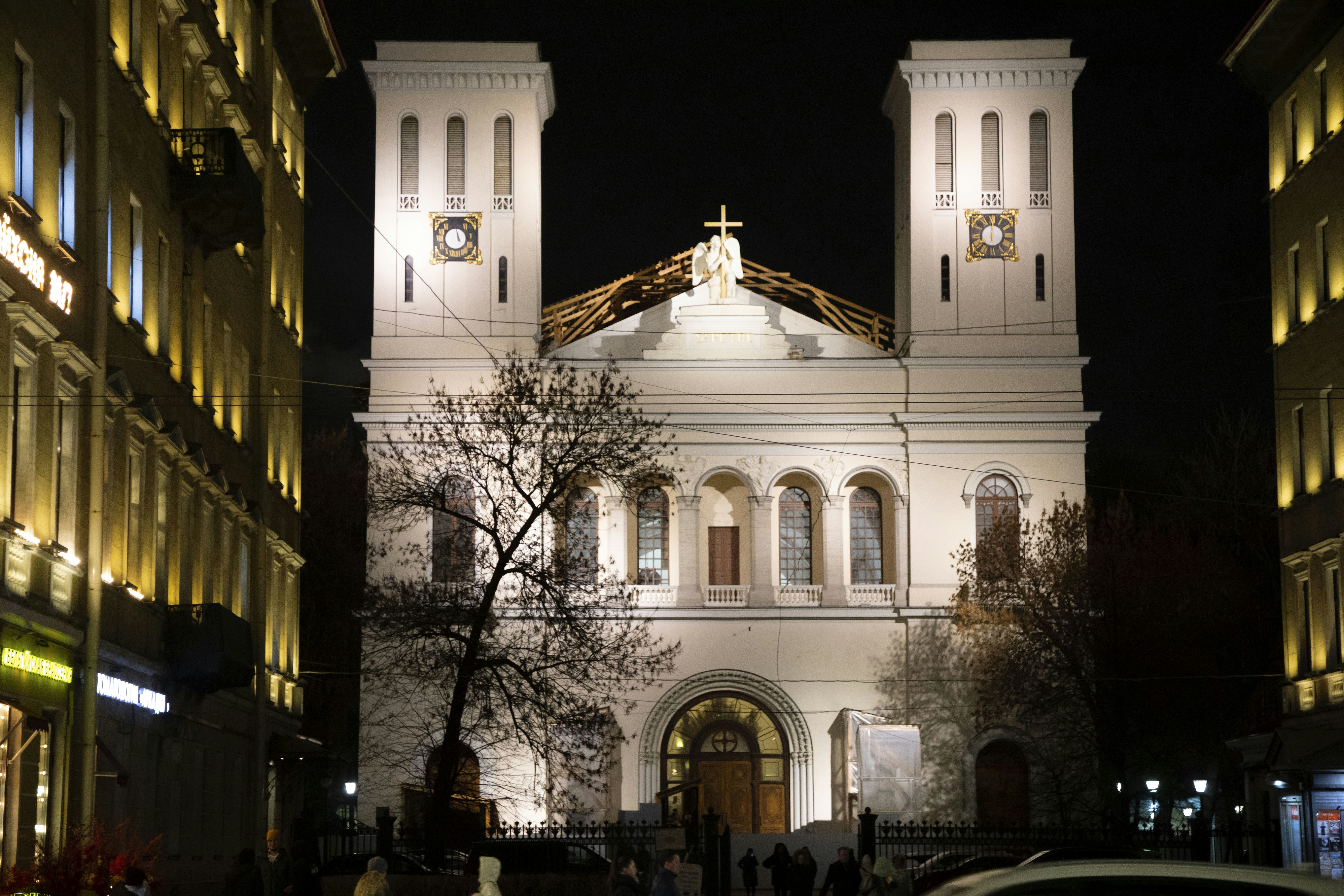 A car is parked in front of a church at night
