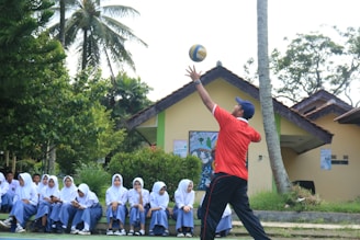 A man in a red shirt is throwing a ball